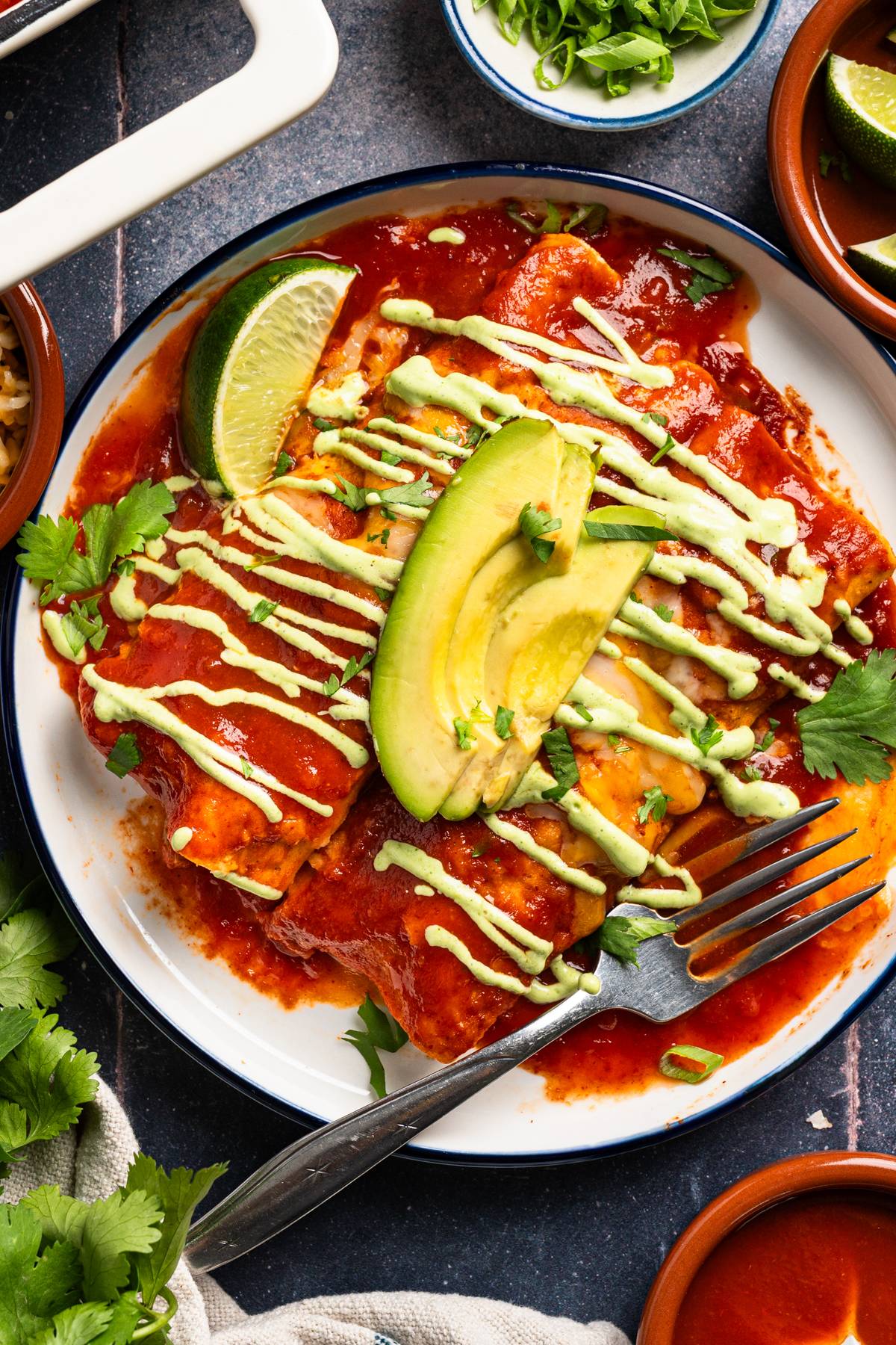 Chicken Enchiladas (with corn tortillas and cilantro lime crema) - on a white plate.