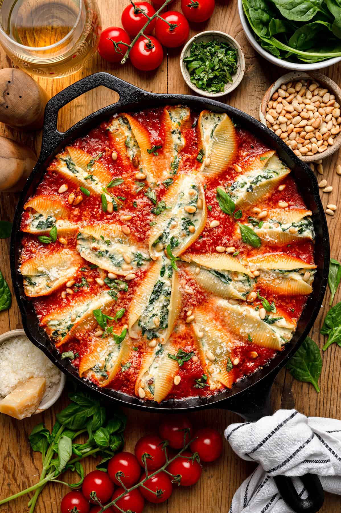 Stuffed Jumbo Pasta Shells (with a creamy mix of ricotta, mozzarella, parmesan, sautéed spinach, and nestled into a skillet of rich marinara sauce.) in a cast iron skillet.