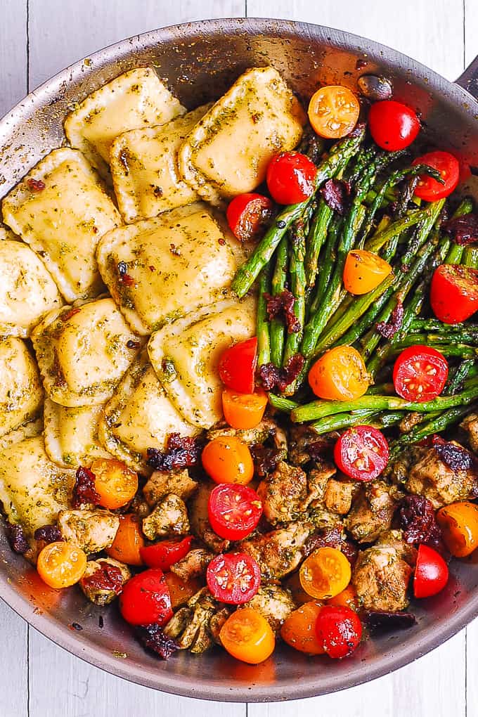 Chicken Ravioli with Basil Pesto and Veggies in a skillet.