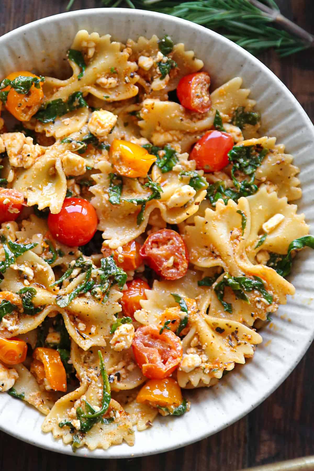 Feta Pasta with Spinach and Cherry Tomatoes in a white bowl.