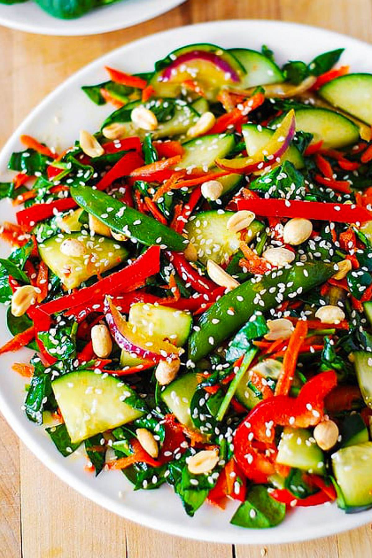 Crunchy Asian Cucumber Salad with Veggies and Peanut Dressing on a plate.
