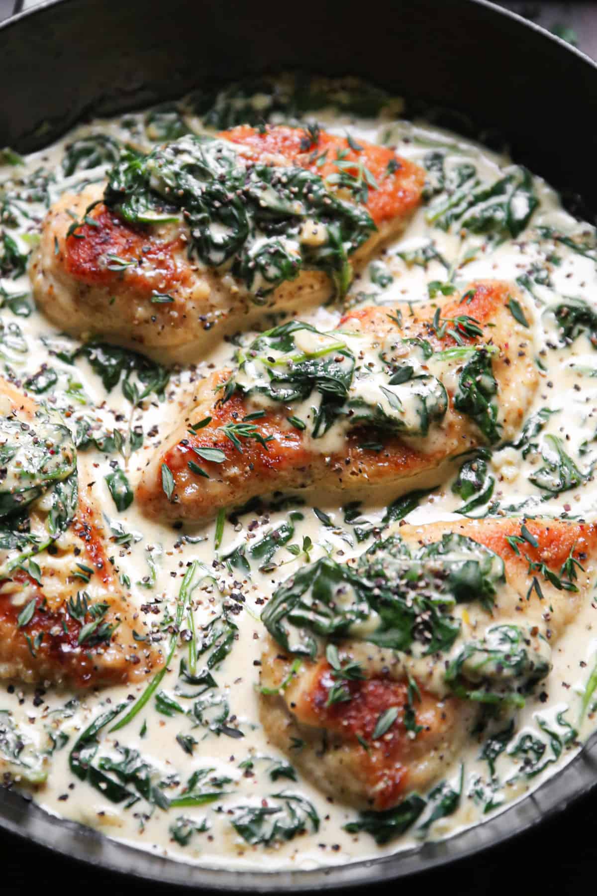 Creamy Parmesan Spinach Chicken in a cast iron skillet.