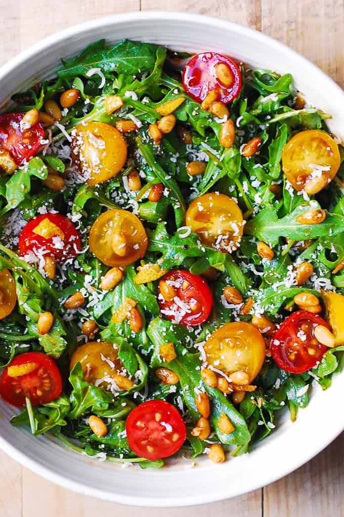 Tomato Arugula Salad with Parmesan and Pine Nuts in a bowl.