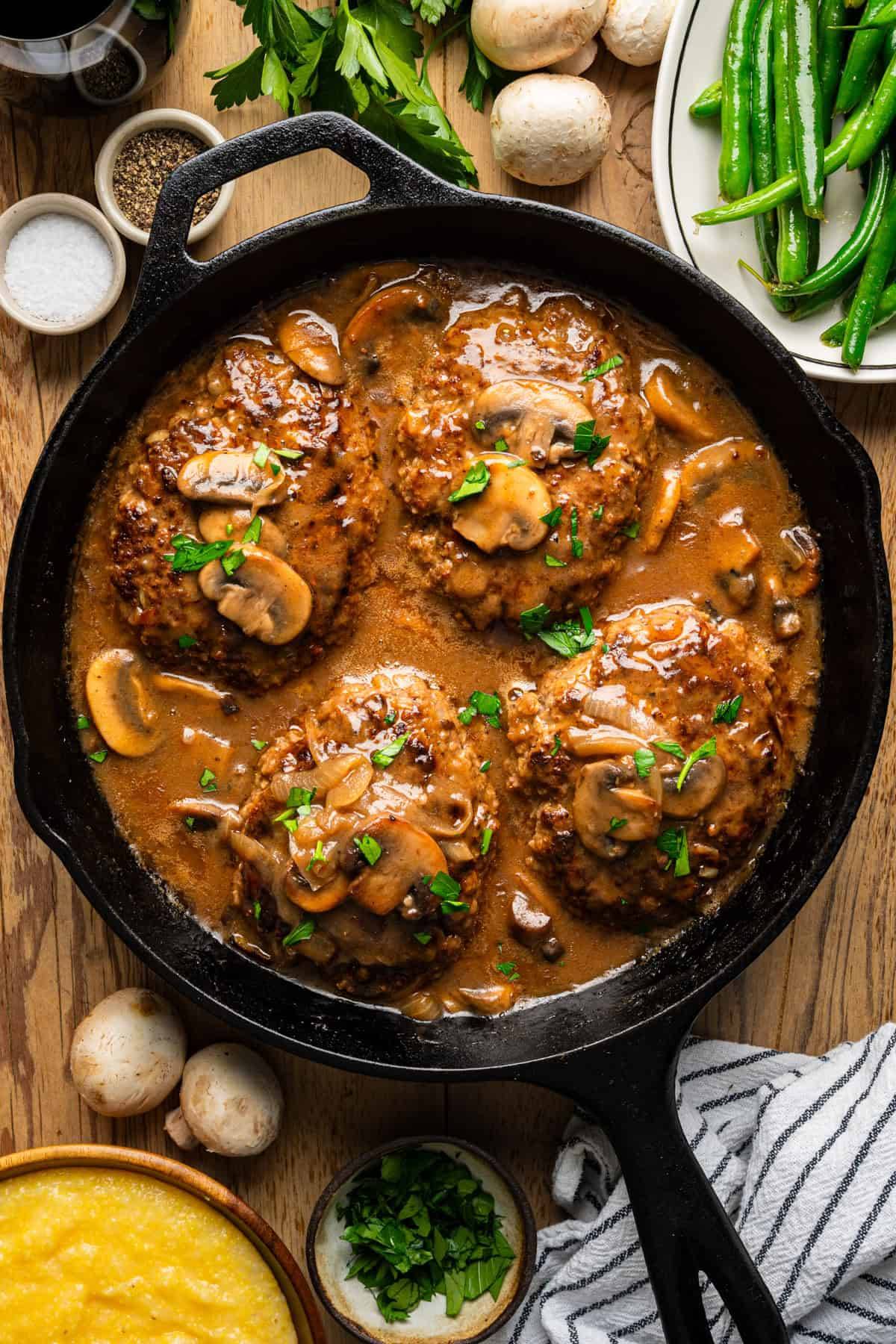 Salisbury Steak with Mushroom Gravy in a cast iron skillet.