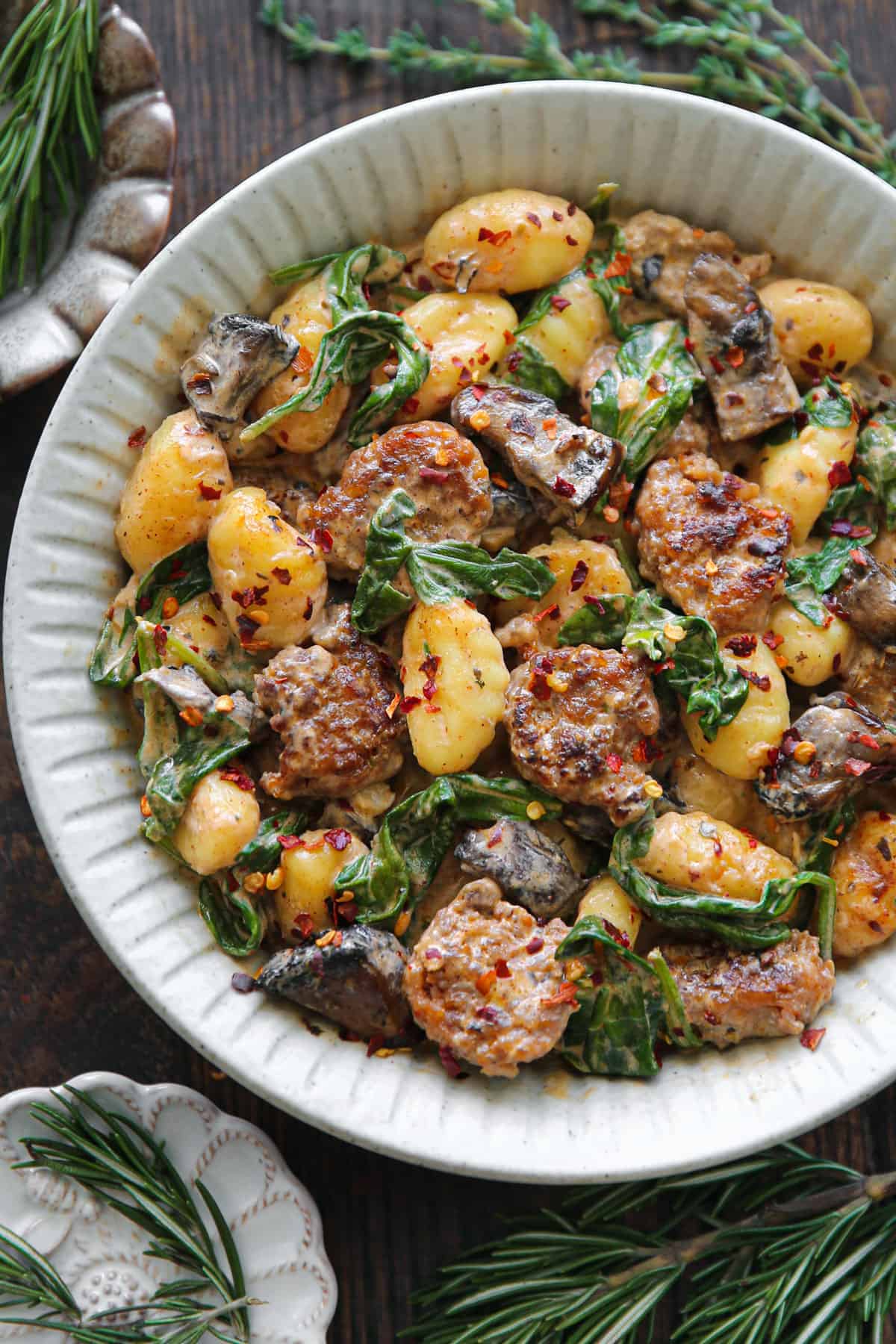 Creamy Italian Gnocchi with Sausage, Mushrooms, Spinach, and Smoked Paprika Cream Sauce on a white plate.