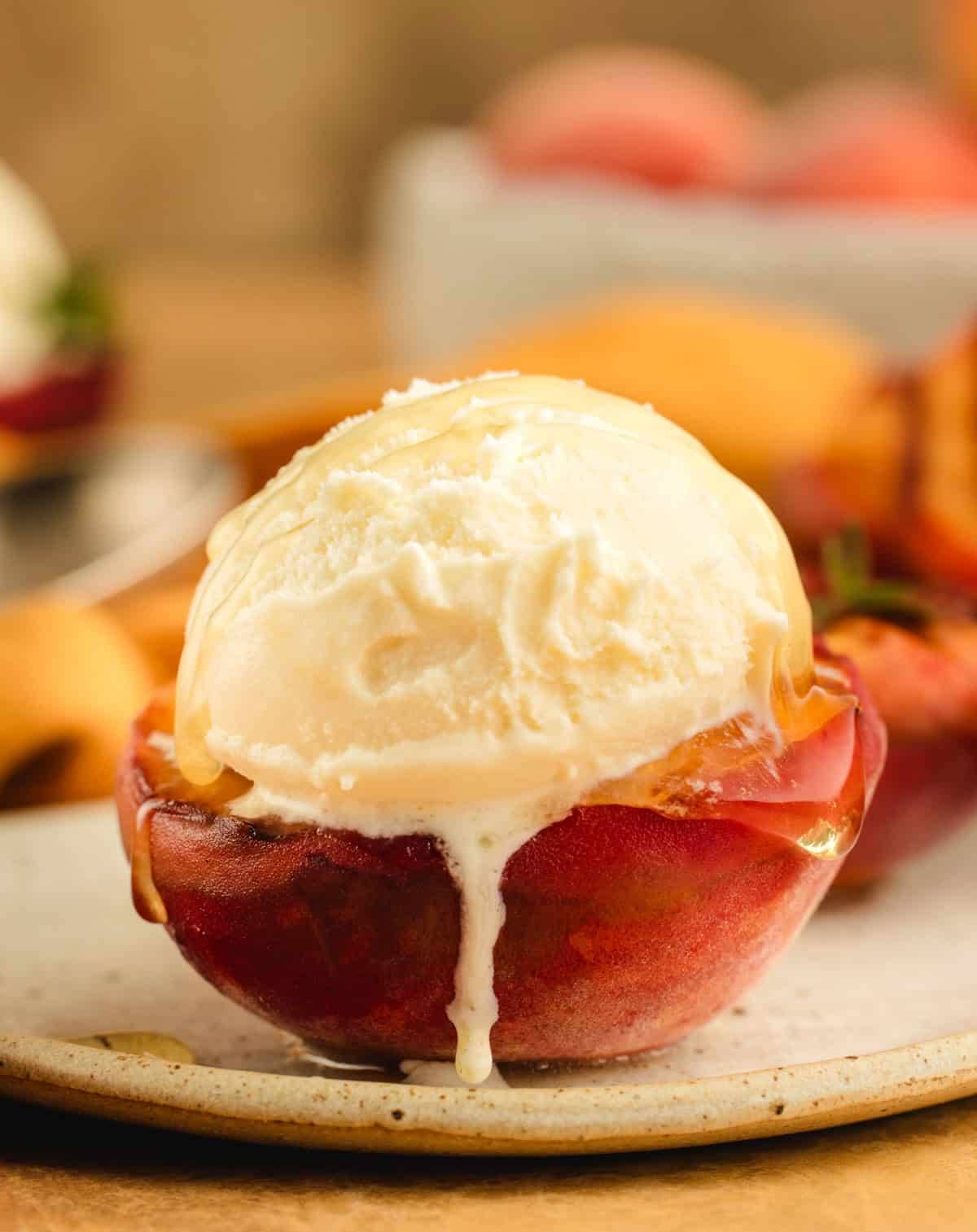Grilled peach half topped with ice cream.