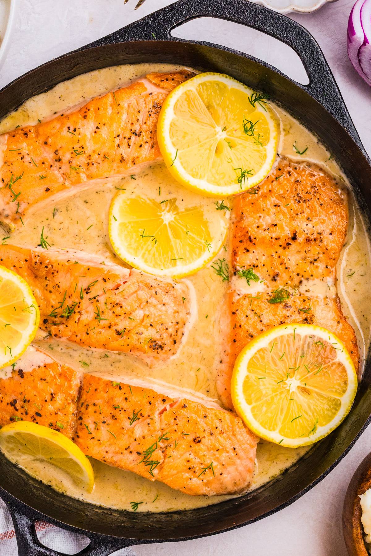 Salmon with Lemon Dill Sauce in a cast iron skillet.