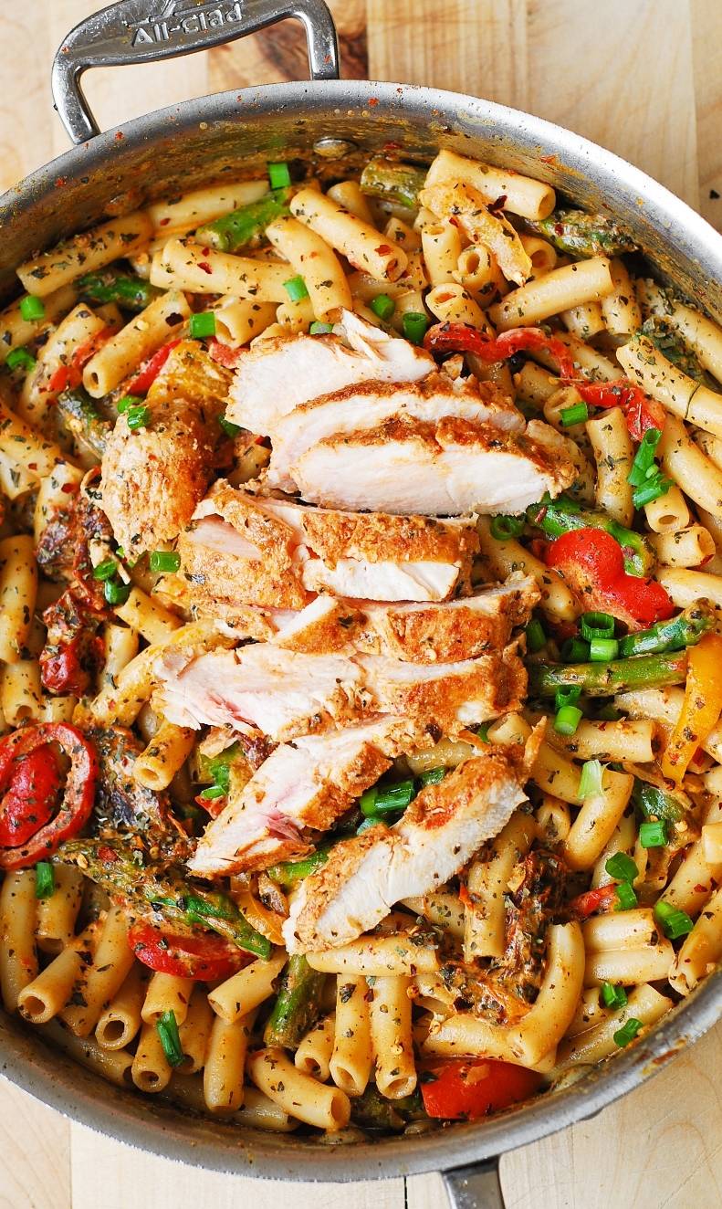 Creamy Chicken Pasta with Bell Peppers, Asparagus, and Creamy Sun-Dried Tomato Sauce in a stainless steel pan.