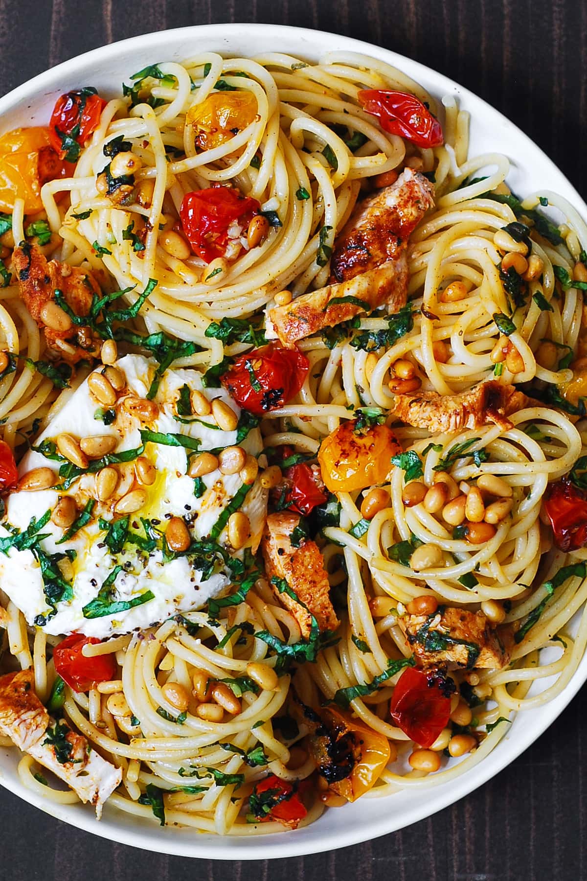 Chicken Spaghetti with Burrata Cheese, Cherry Tomatoes, and Lemon Butter Garlic Sauce on a white plate.