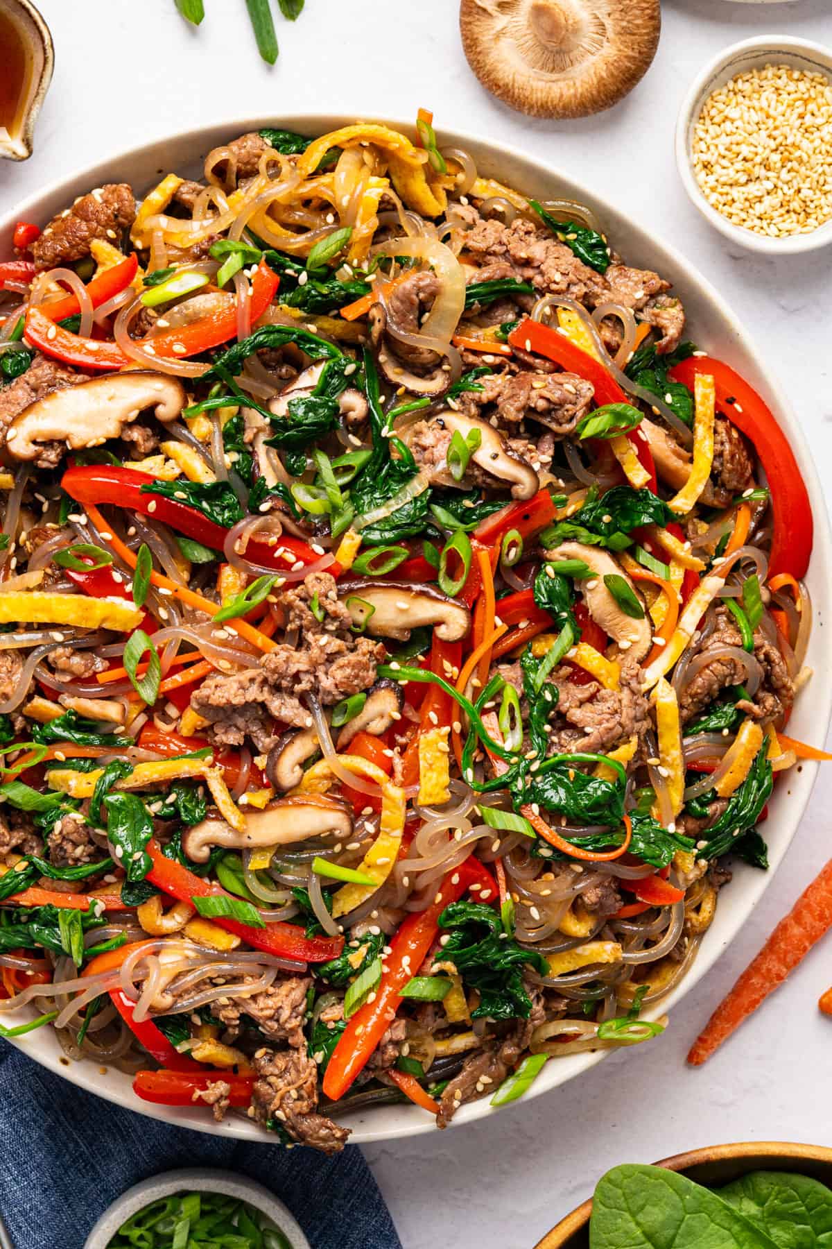 Korean Noodles with Marinated Beef & Vegetables - on a white plate.