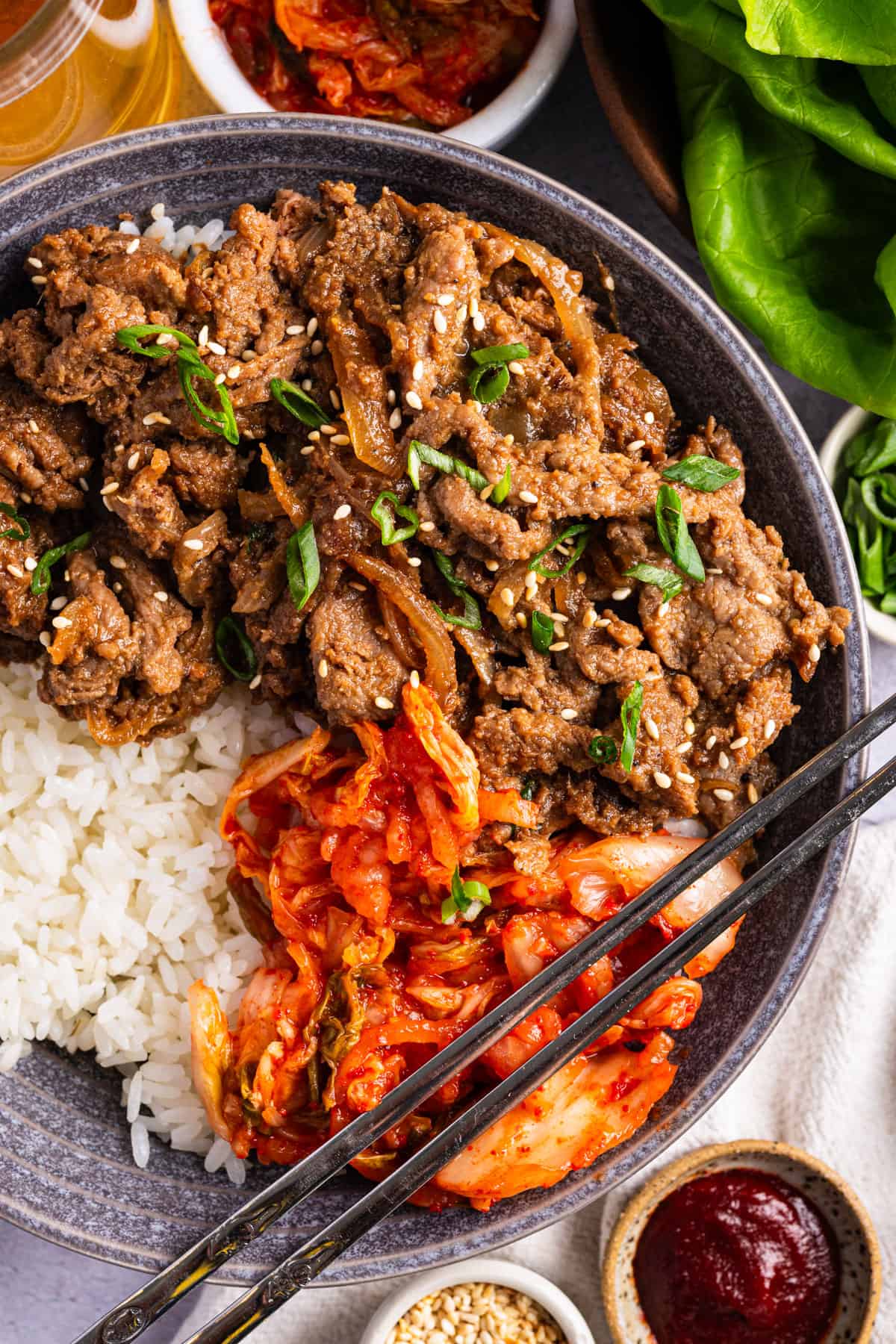 Beef Bulgogi Bowls (Korean BBQ Meat) with Rice, Kimchi, and Green Onions.