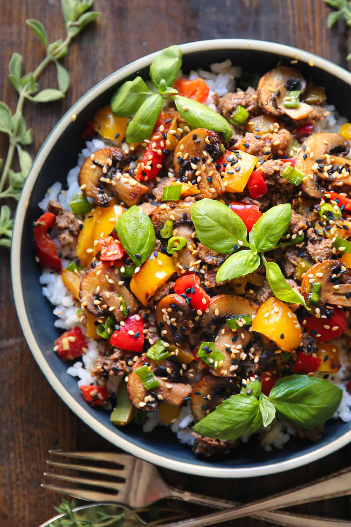 Ground Beef Stir Fry with Vegetables over rice in a blue bowl.