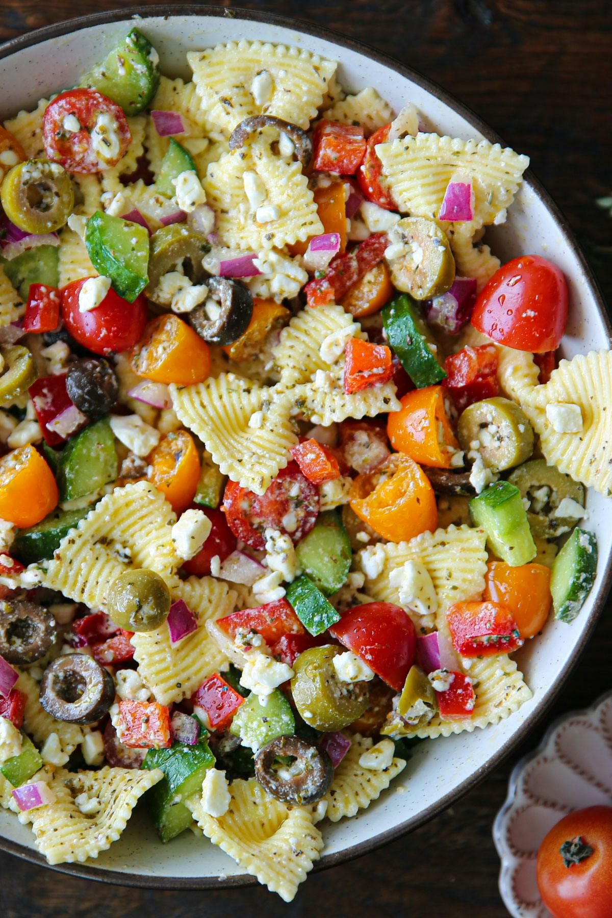 Greek Pasta salad with Tomatoes, cucumber, bell pepper, olives, red onions, and feta cheese.