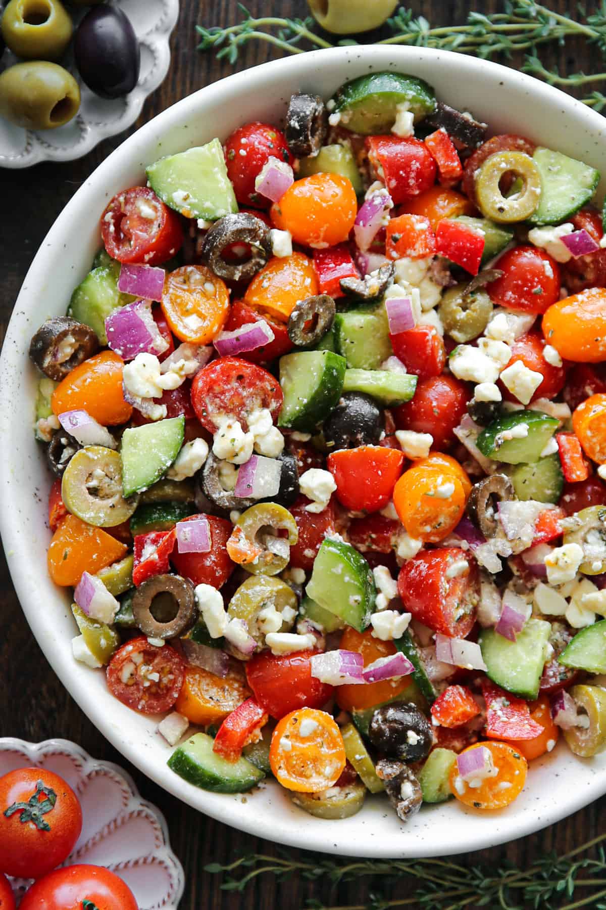 Greek salad with chopped tomatoes, cucumbers, olives, red onion, and feta cheese - in a bowl.