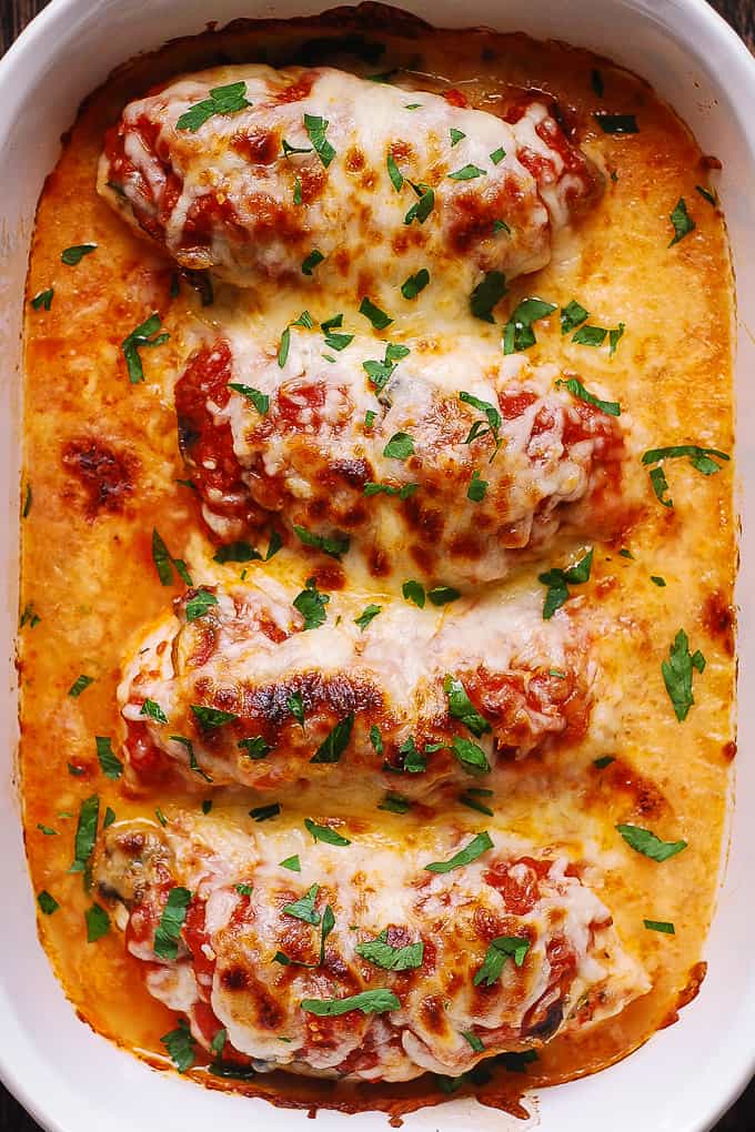 Easy Baked Mozzarella Chicken with Mushrooms and Tomato Sauce - in a white casserole dish.