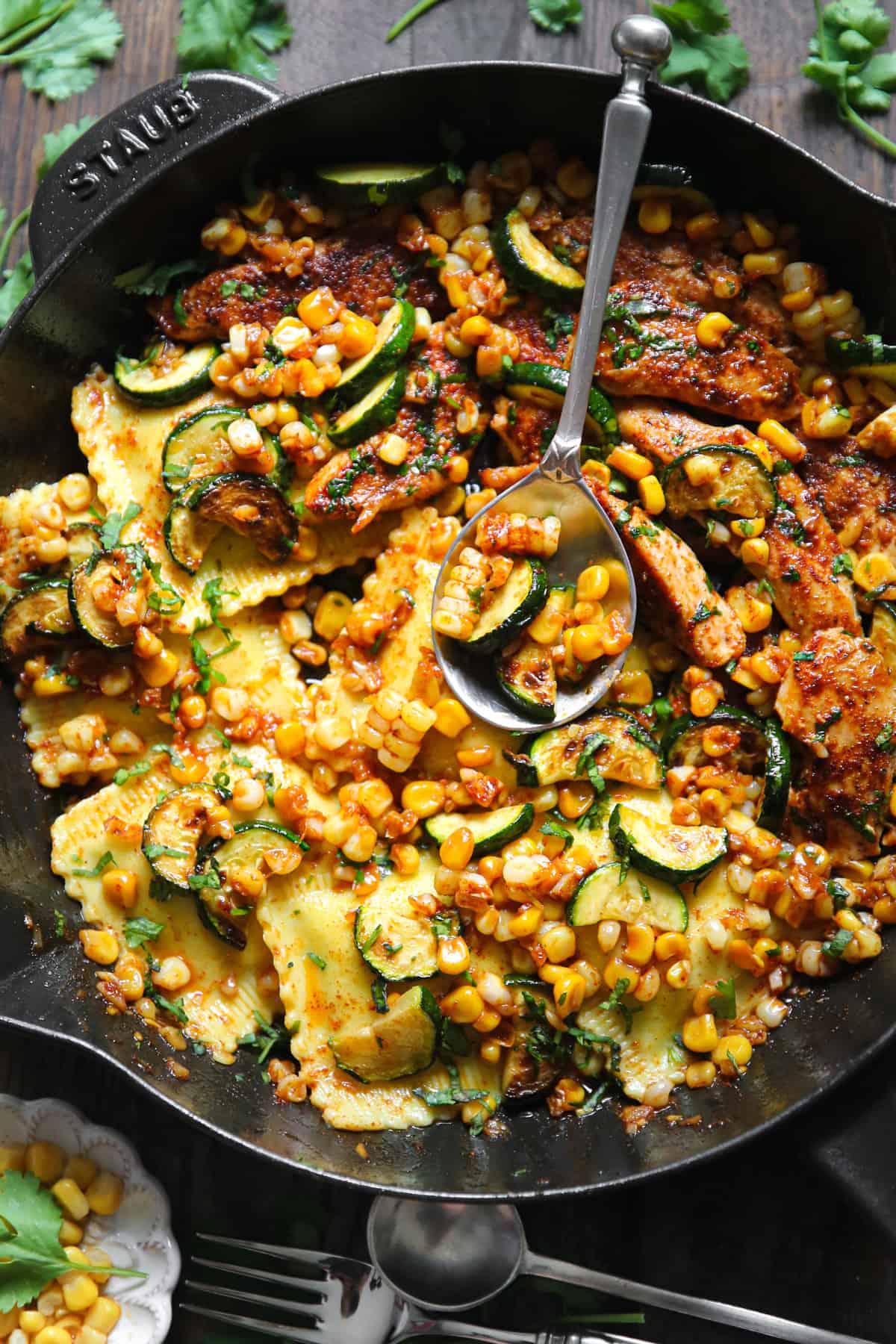 Garlic Butter Chicken with Zucchini, Corn, and Ravioli in a cast iron skillet.
