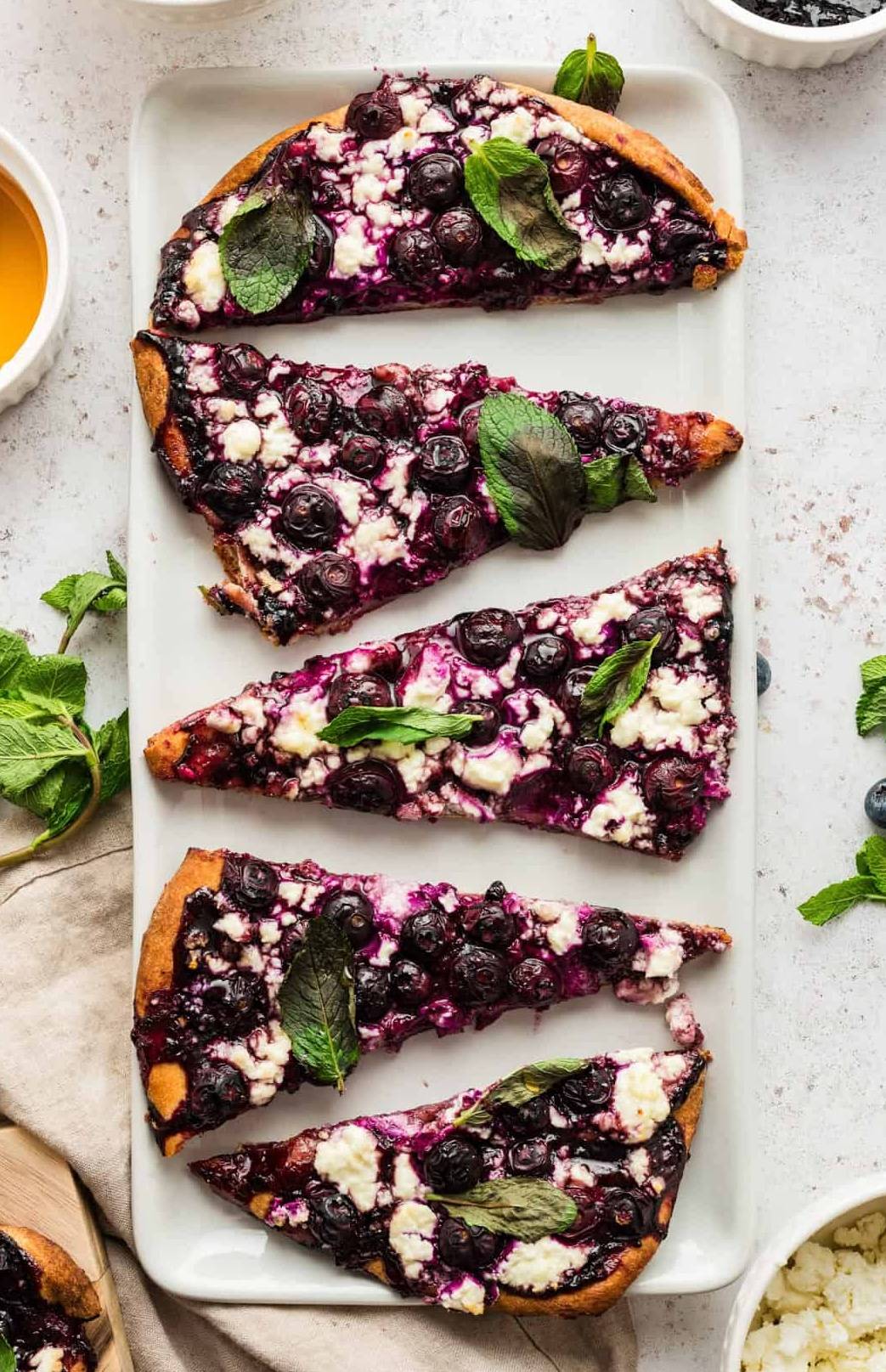 Blueberry Flatbread, sliced on a white plate.