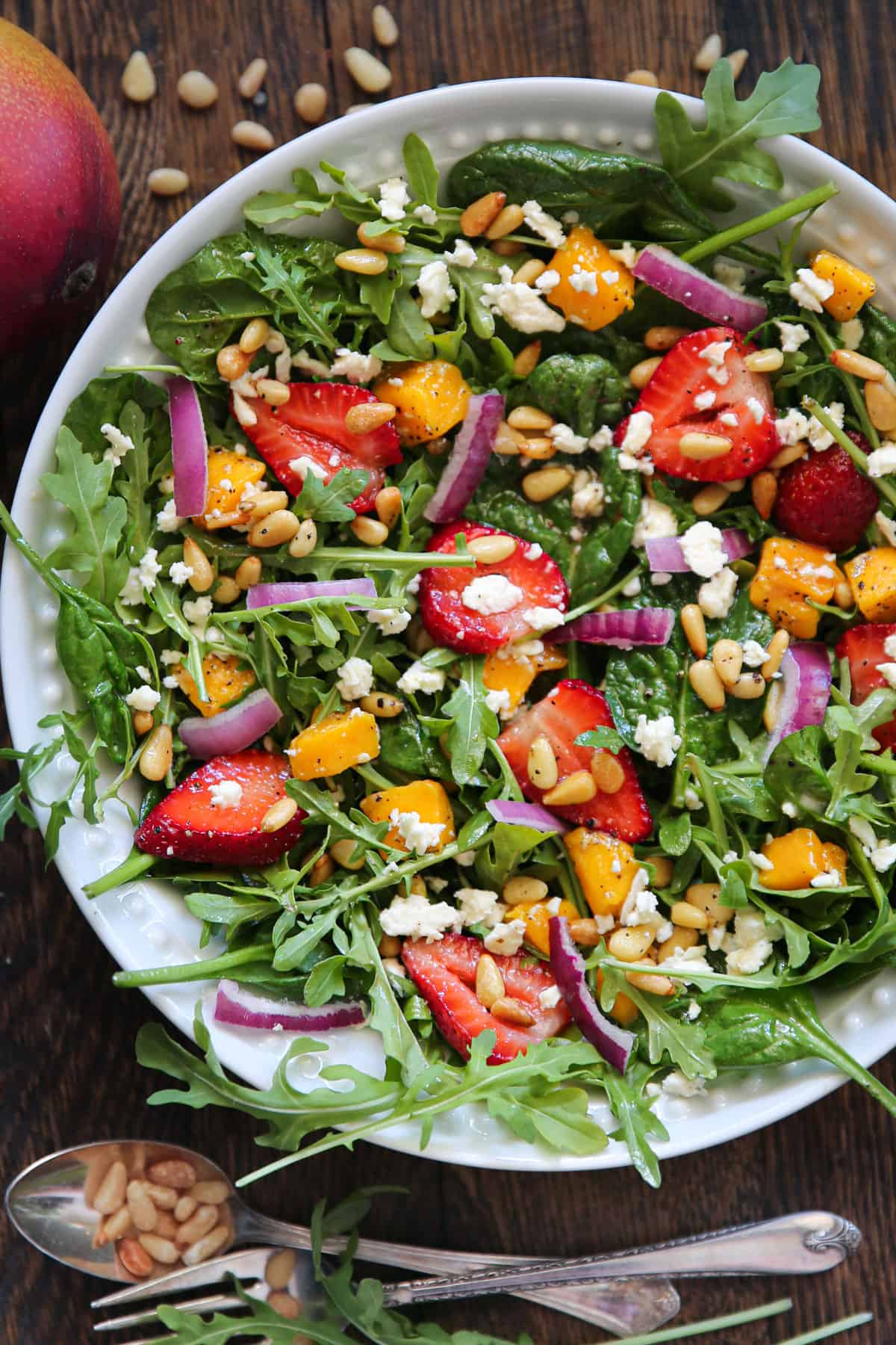 Strawberry Mango Salad with Spinach & Arugula in a bowl.