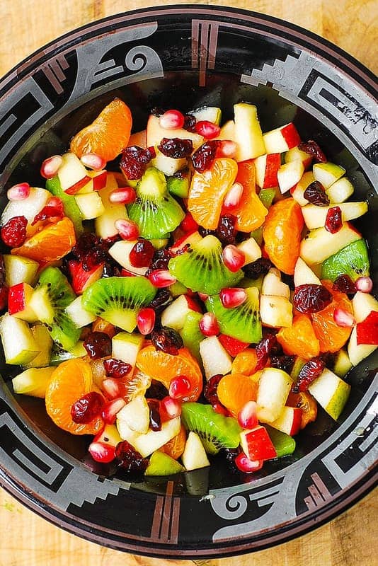 Winter Fruit Salad with Maple-Lime Dressing in a black bowl.