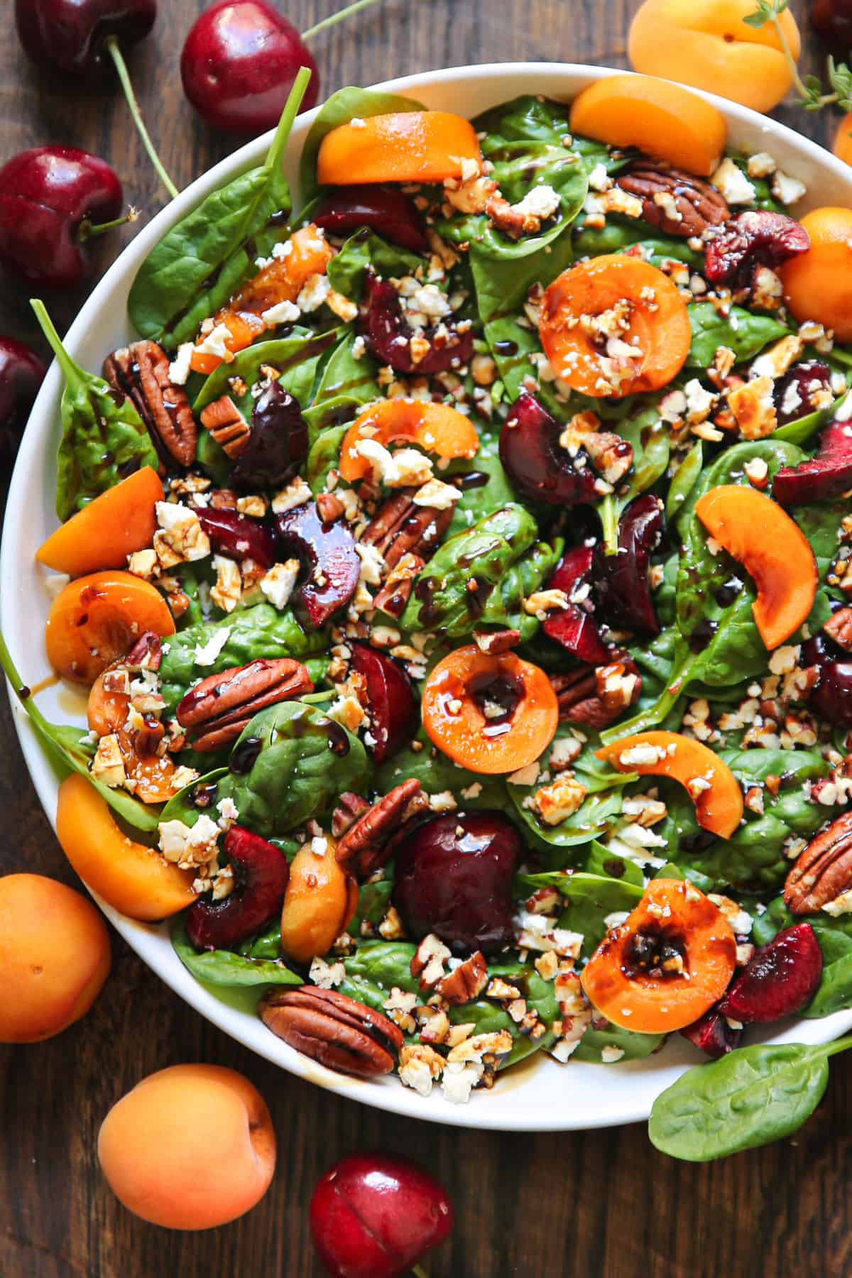 Apricot Spinach Salad with Spinach, Cherries, Pecans, Feta Cheese, and Balsamic-Honey Glaze in a bowl.