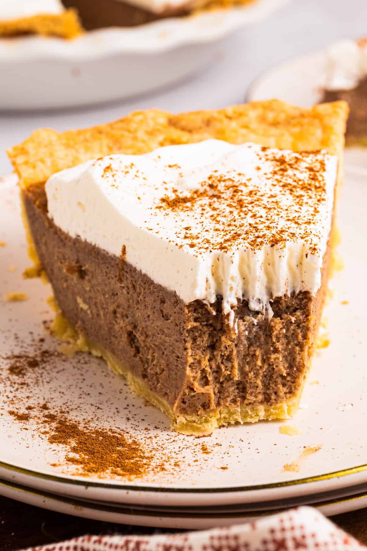 A slice of Cinnamon Pie with whipped cream on top - on a plate.