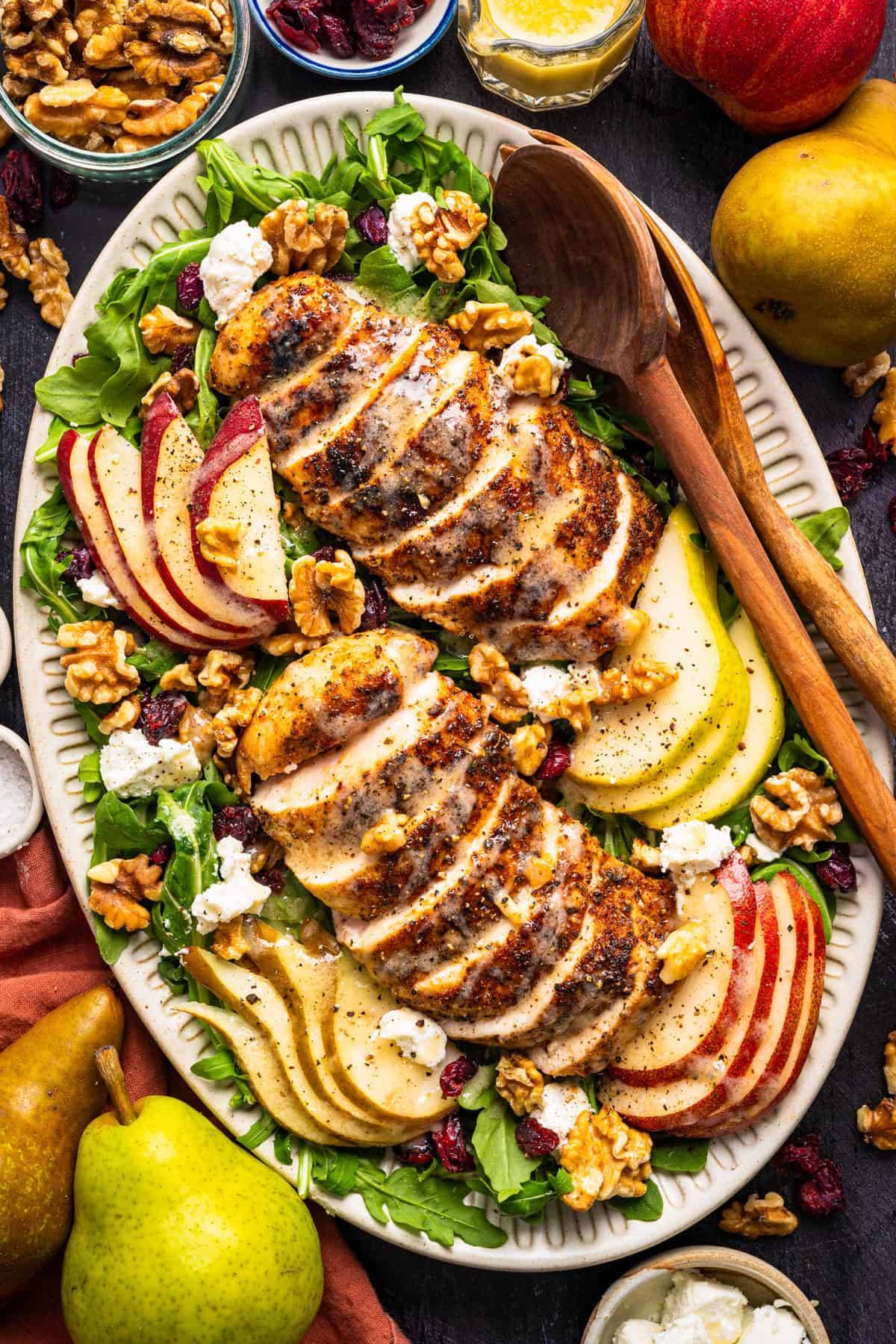 Chicken Arugula Salad with Pears, Goat Cheese, and Walnuts on a large platter.
