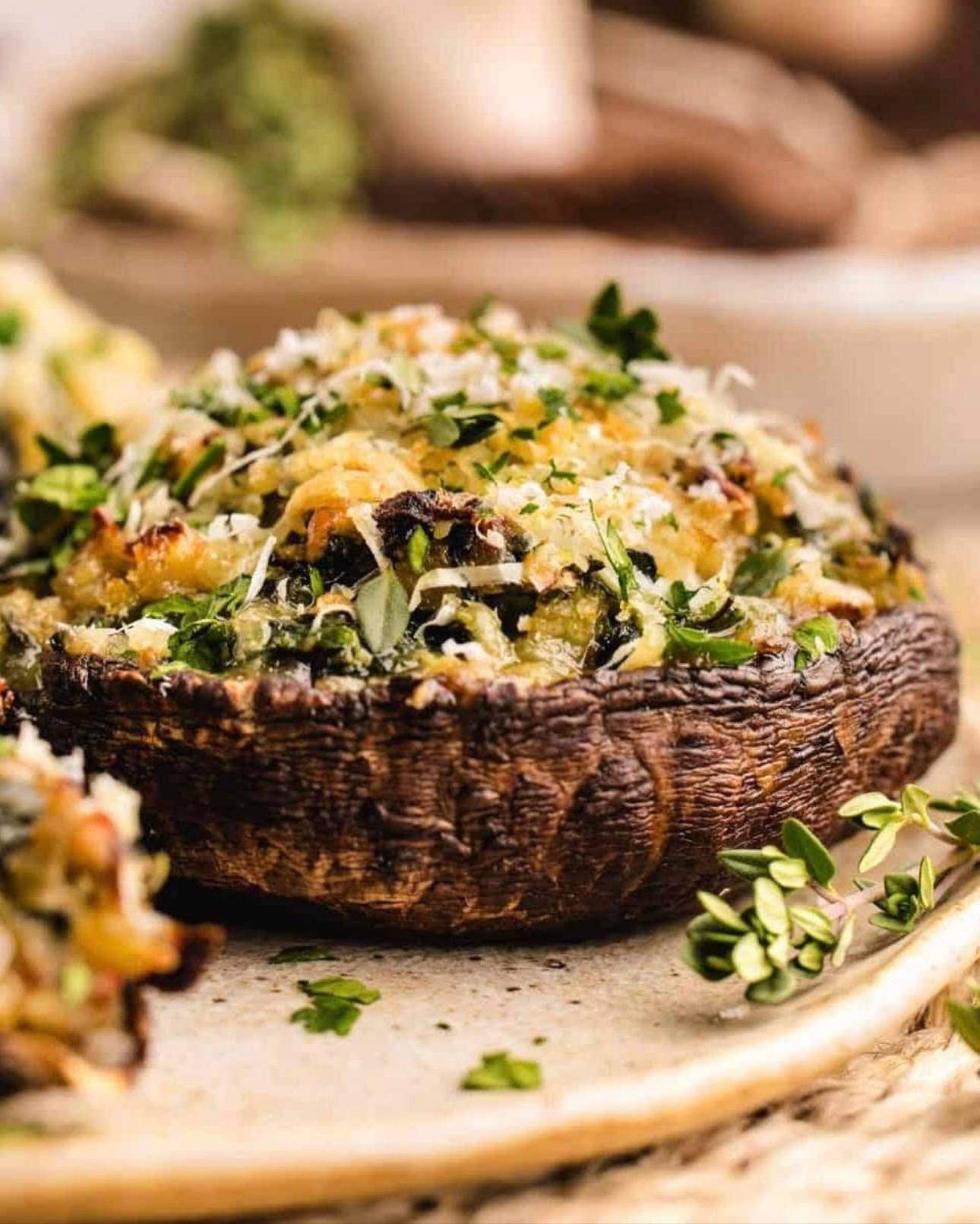Baked Stuffed Portobello Mushrooms​ (with a savory filling of spinach, garlic, Gruyère, Parmesan, and breadcrumbs) - on a plate.