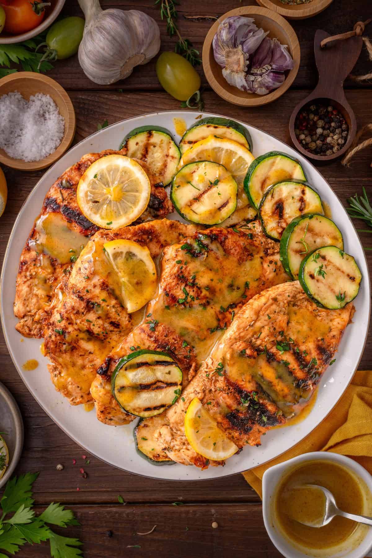Grilled Chicken Breasts with Honey-Lemon-Mustard Marinade and Glaze, with Grilled Zucchini Rounds on a white plate.