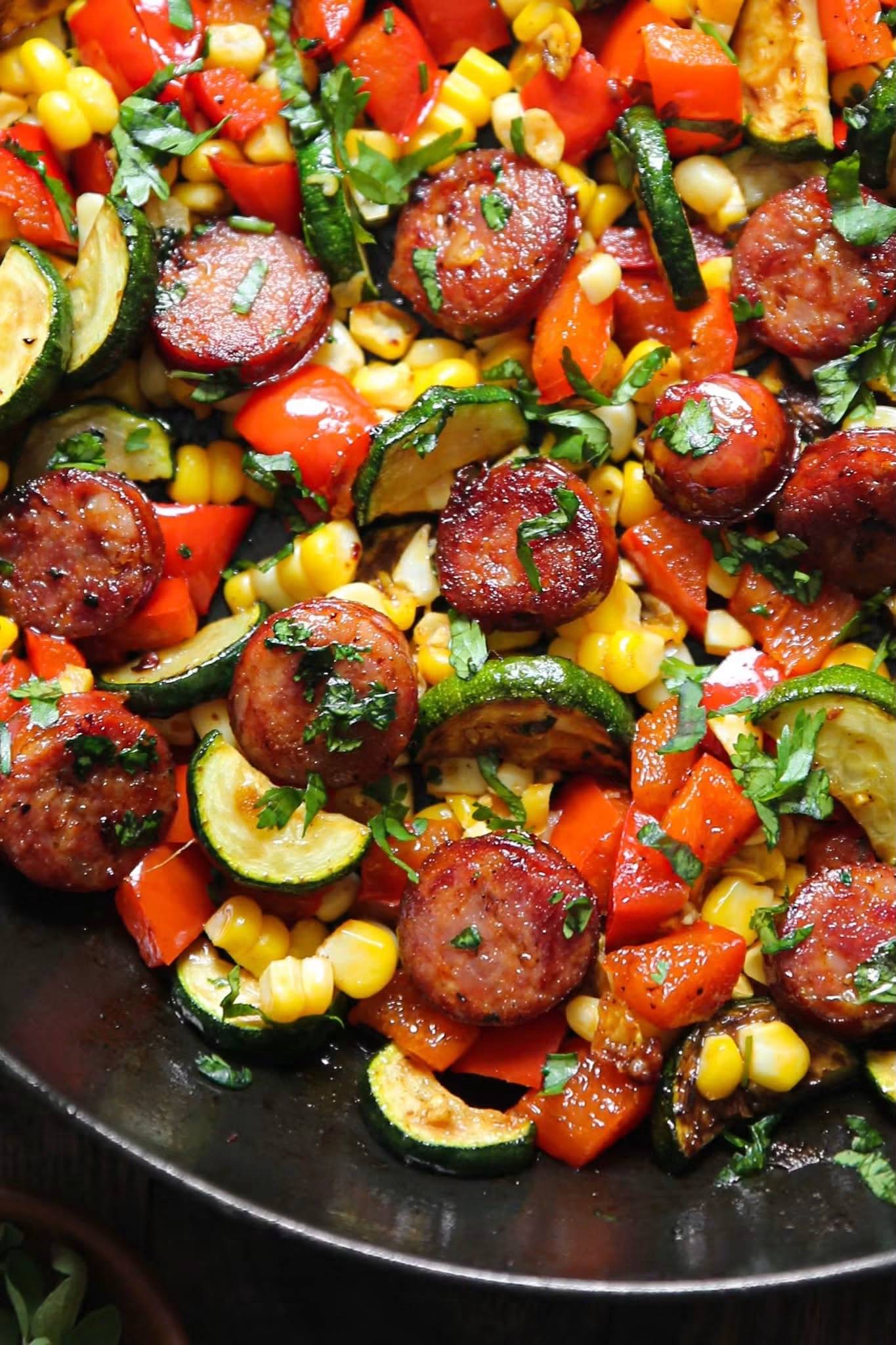 Sausage and Veggies Skillet with Bell Peppers, Zucchini, Corn, and Cilantro in a cast iron skillet.