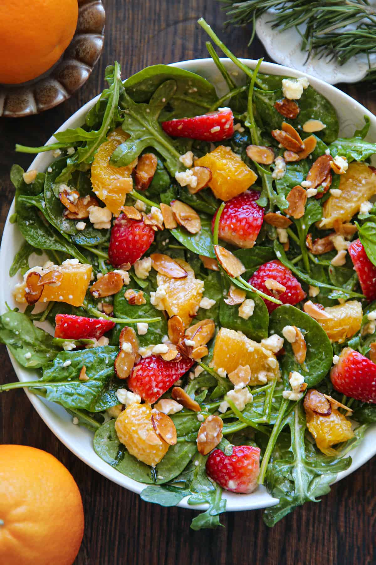 Strawberry Orange Salad with Spinach, Arugula, Toasted Sliced Almonds, and Feta Cheese in a bowl.