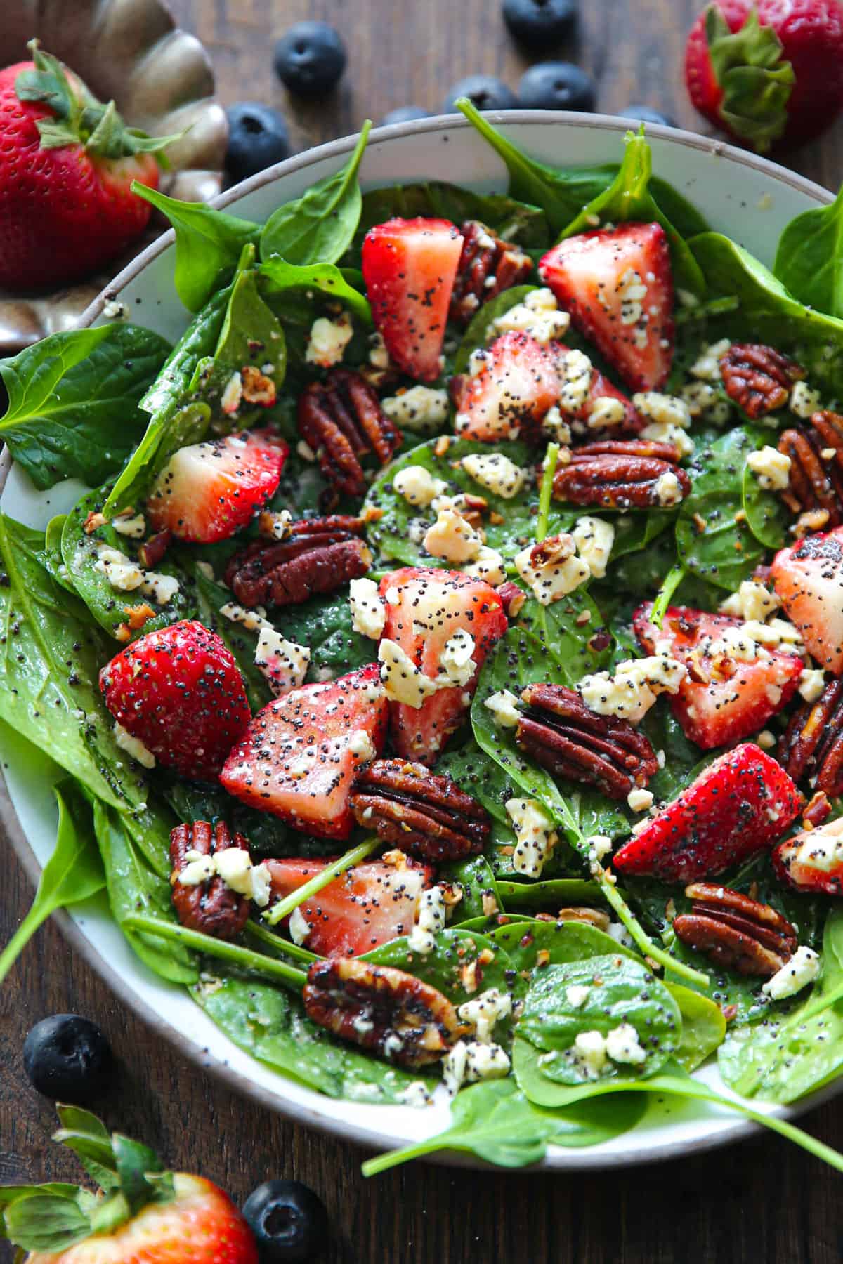 Strawberry Spinach Salad with Poppy Seed Honey-Lemon Dressing in a white plate.