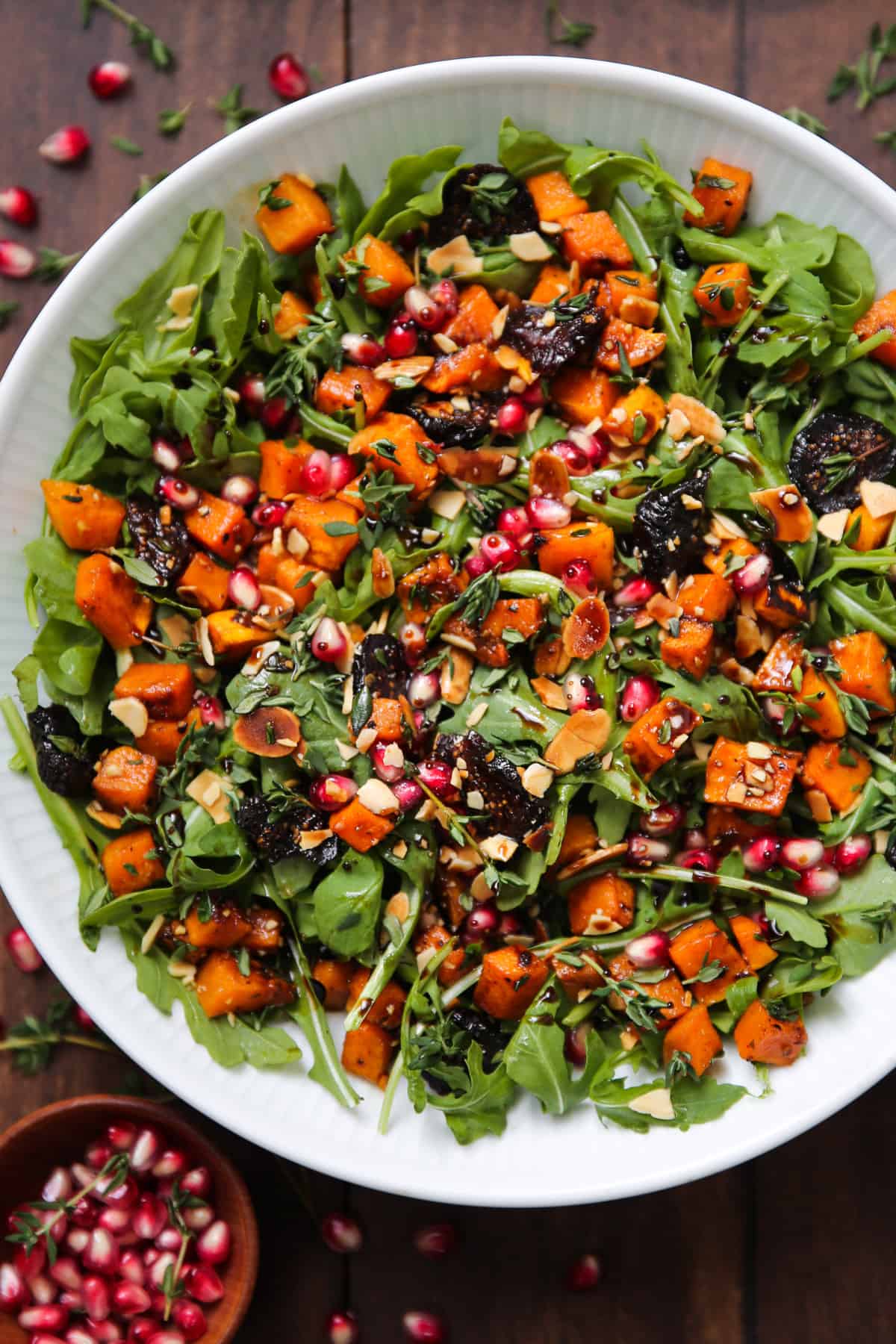 Winter Salad with Roasted Butternut Squash, Arugula, Dried Figs, and Almonds - in a bowl.