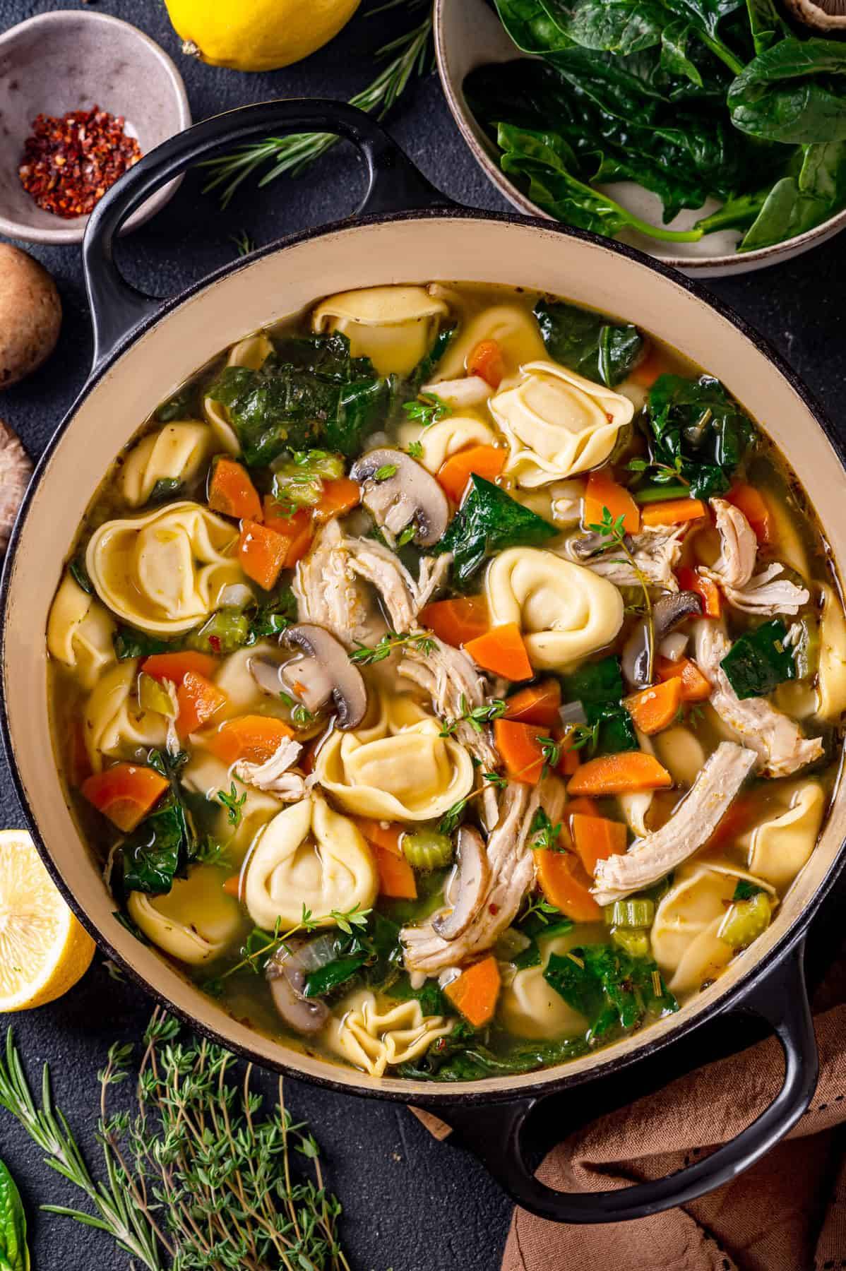 Lemon Chicken Tortellini Soup with Spinach & Mushrooms in a Dutch oven.