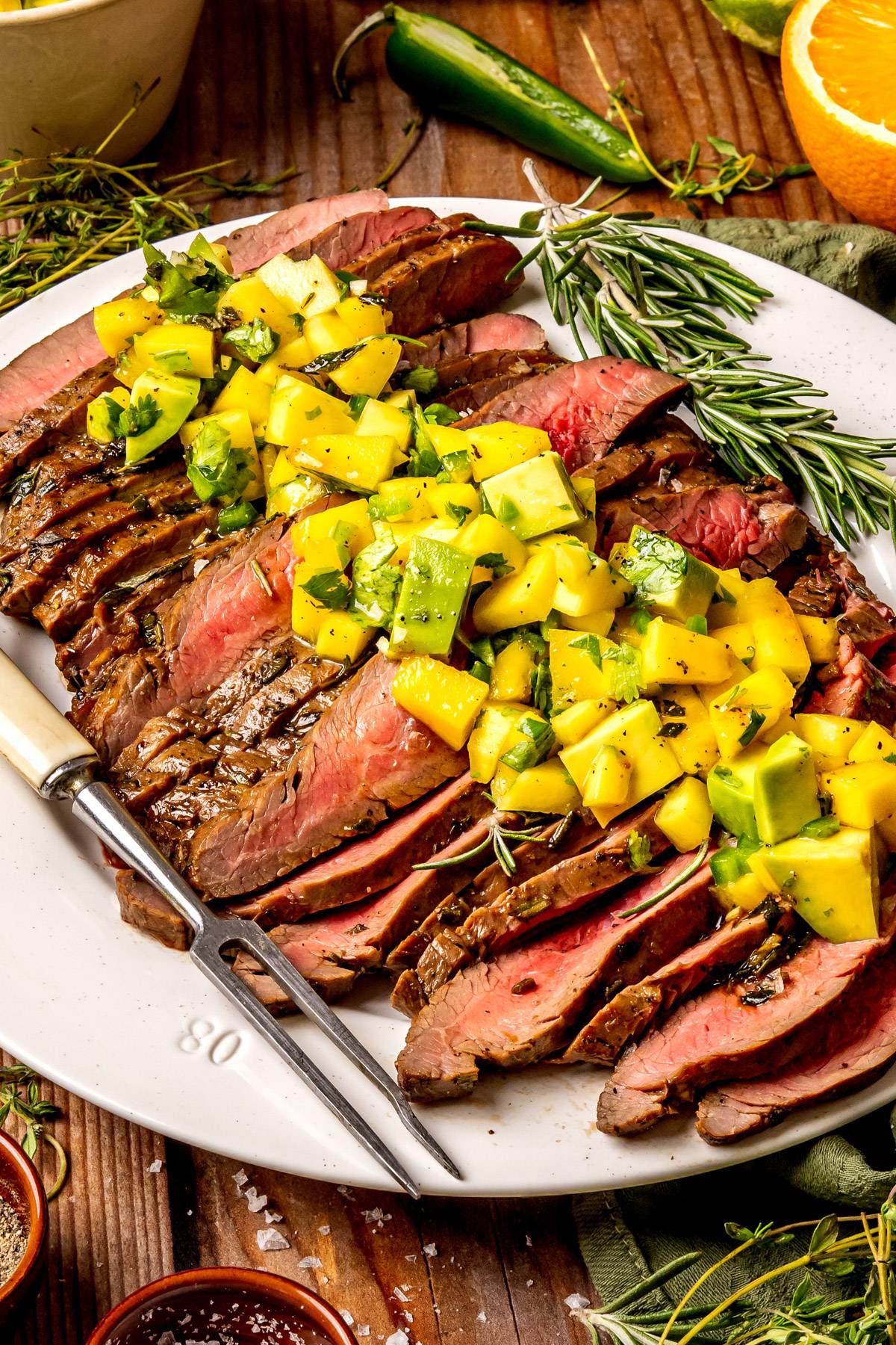 Grilled Flank Steak with Mango Avocado Salsa on a white plate.