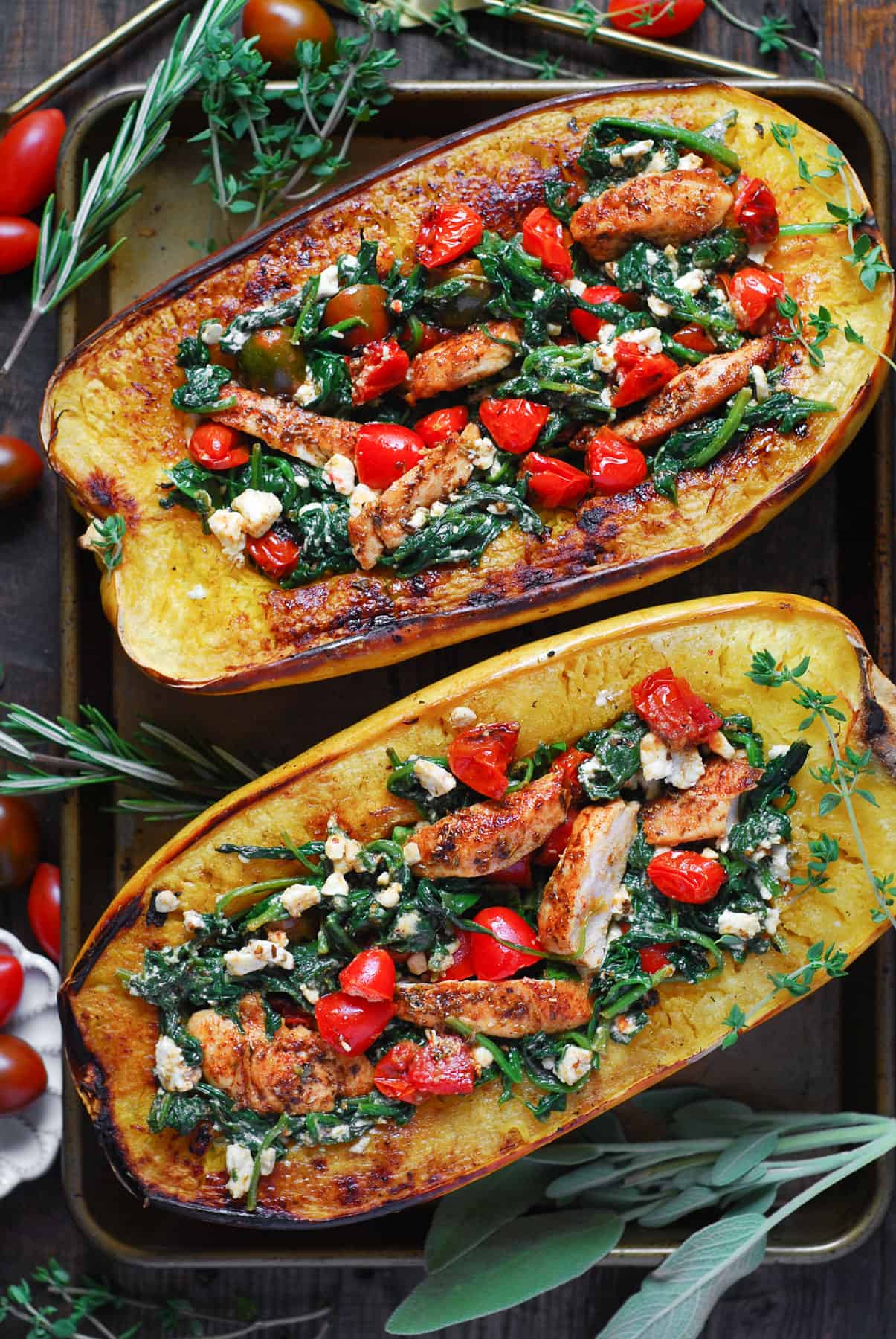 Spaghetti Squash Stuffed with Chicken, Tomatoes, Spinach, and Feta Cheese on a sheet pan.