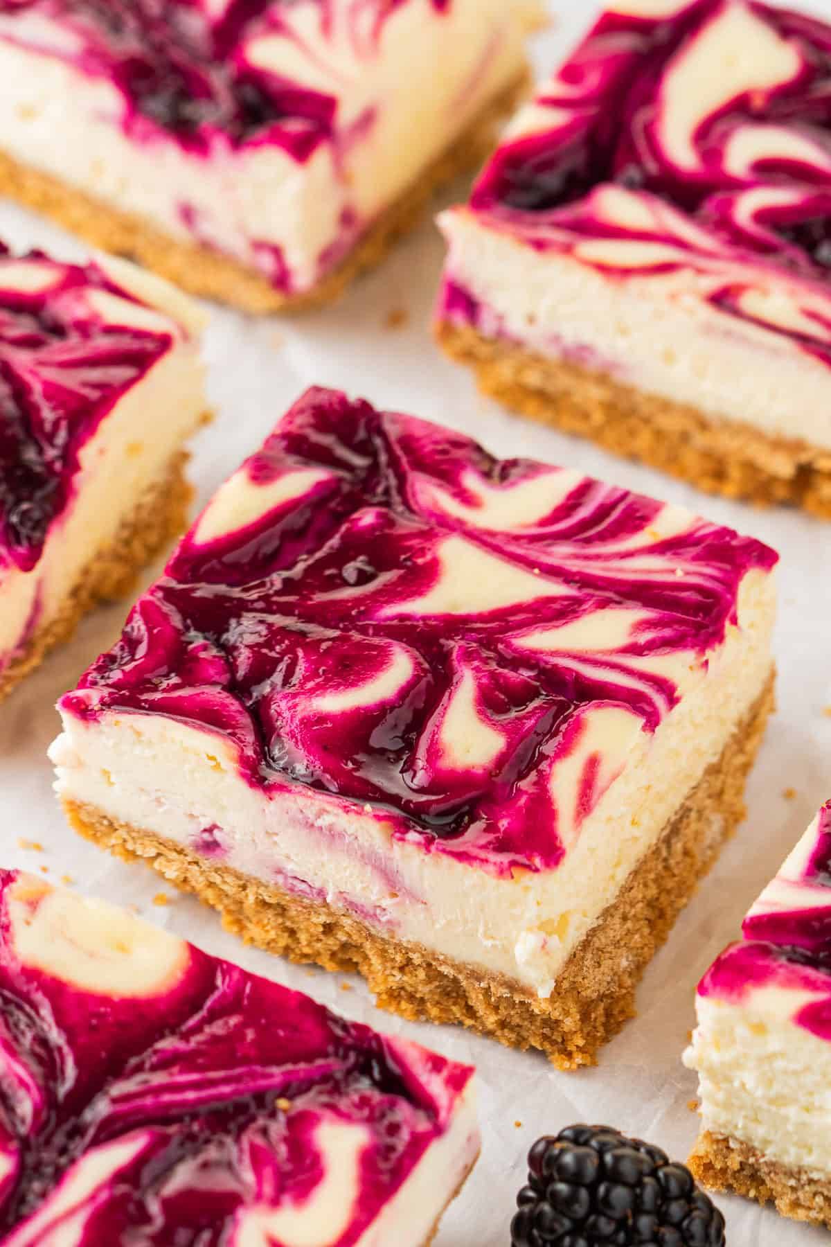 Blackberry Cheesecake Bars on a white surface.