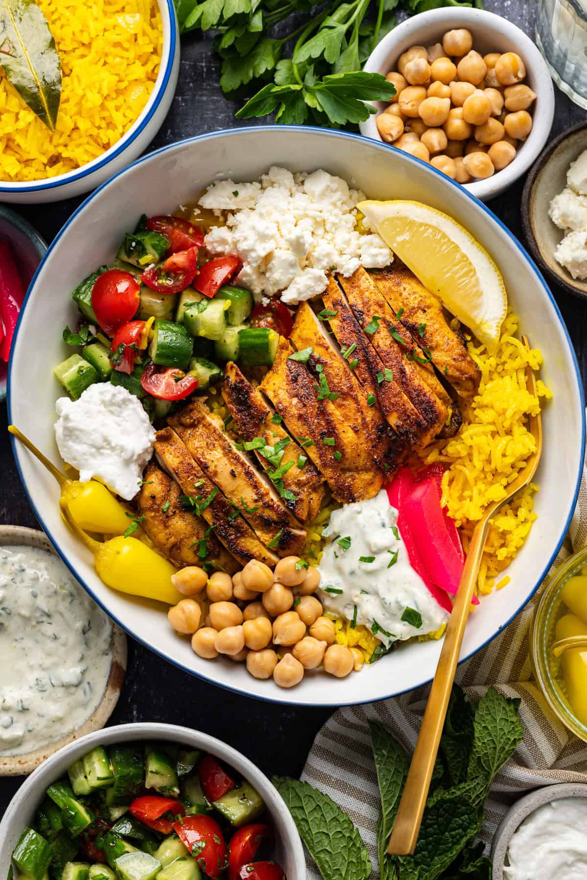 Lemon-Garlic Grilled Chicken Bowls (with rice, homemade tzatziki, a fresh tomato-cucumber salad, chickpeas, and feta)