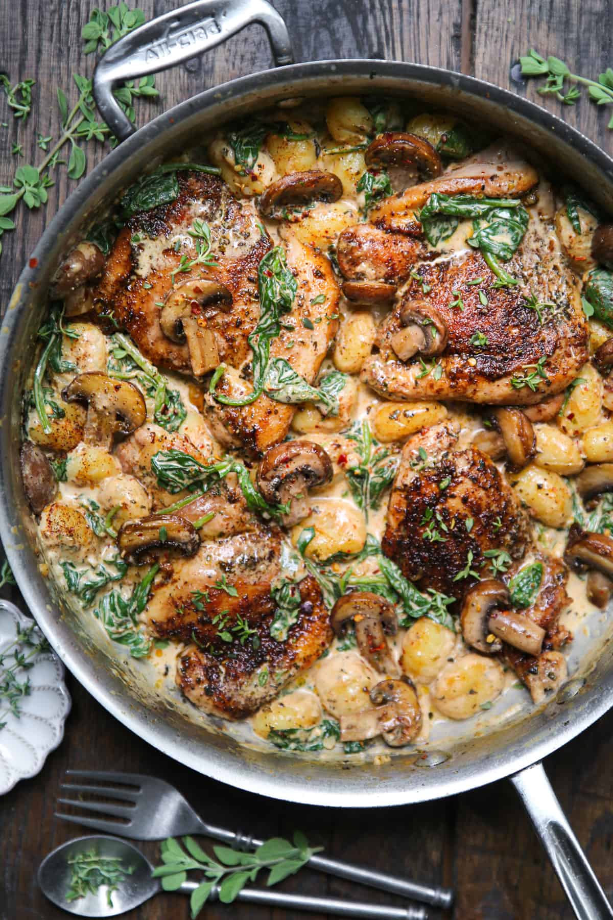 Creamy Chicken Thighs and Gnocchi with Spinach, Mushrooms, and Creamy Smoked Paprika Garlic Sauce in a stainless steel pan.