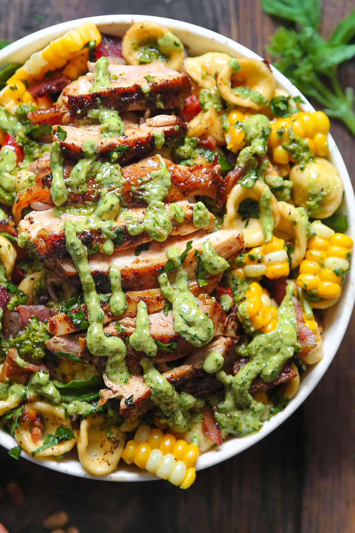 Chicken Corn Bacon Pasta Salad with creamy basil pesto dressing in a bowl.