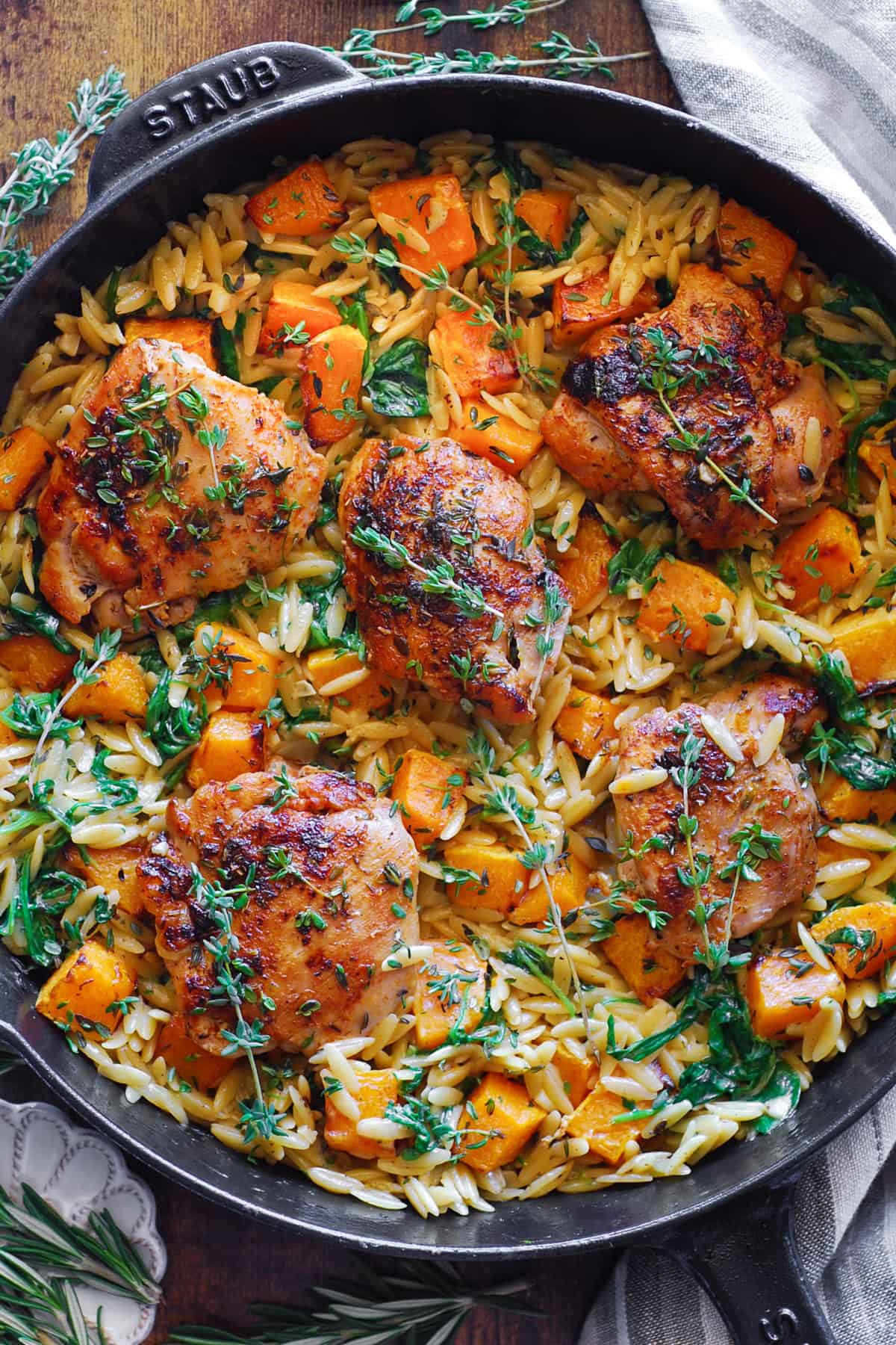 Creamy Chicken Orzo with Butternut Squash and Spinach in a cast iron skillet.