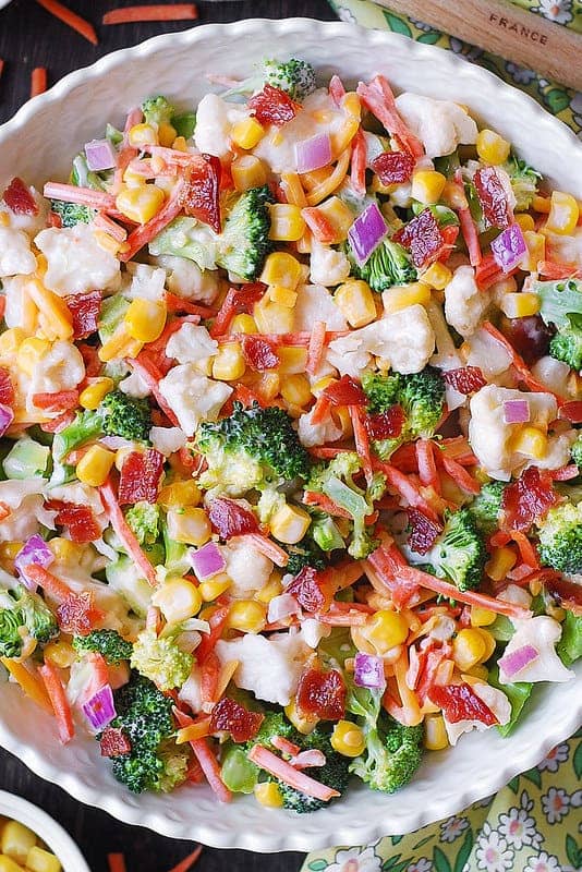 Creamy Broccoli & Cauliflower Salad with Corn, Bacon, Carrots, and Cheddar - in a white bowl.