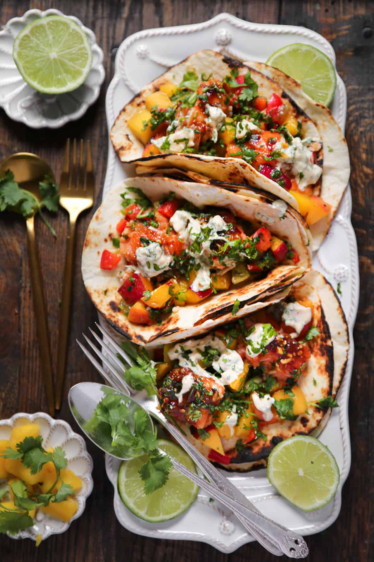 Salmon Tacos with Mango Peach Salsa on a elongated white plate.