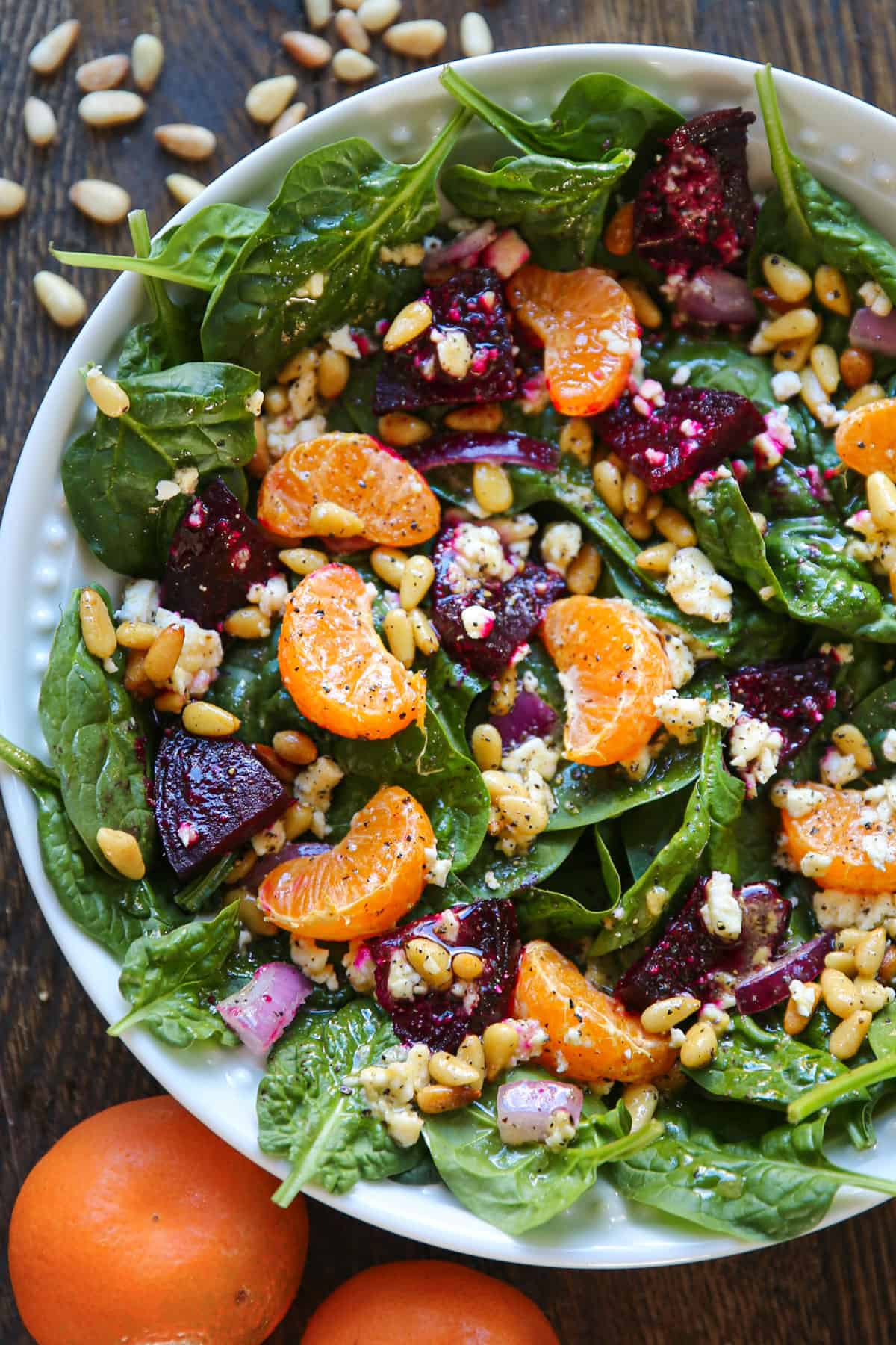 Beet Salad (with spinach, mandarin oranges, red onion, pine nuts, and feta cheese) on a plate.
