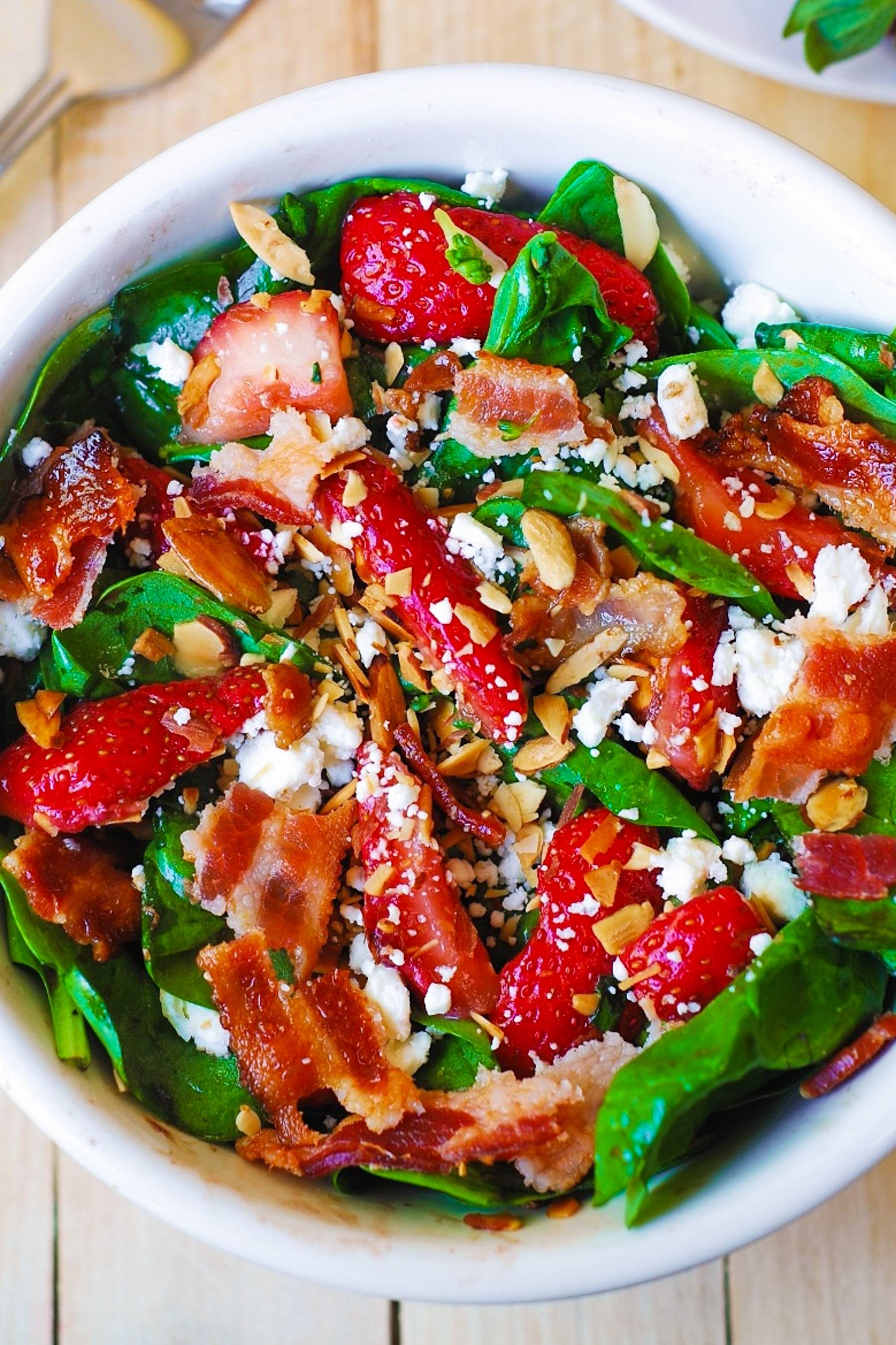 Strawberry Spinach Salad with Bacon and Toasted Almonds in a bowl.