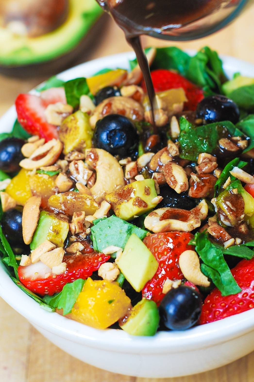  Strawberry Spinach Salad with Mango, Avocado, Blueberries, and Cashew Nuts in a bowl.