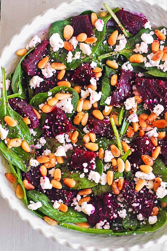 Simple Beet & Spinach Salad with Goat Cheese and Pine Nuts - in a bowl.