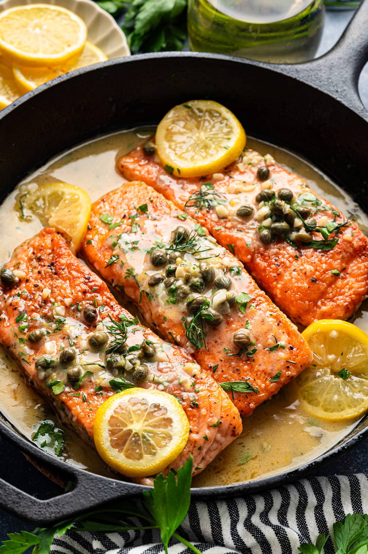 Salmon Piccata (3 salmon fillets) topped with capers - in a cast iron skillet.
