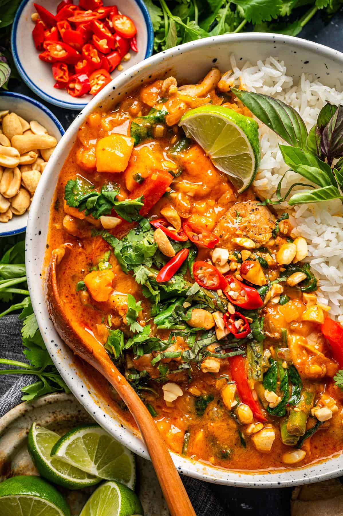 Thai Chicken Curry (with sweet potato, bell pepper, green beans, and spinach) with rice in a bowl.