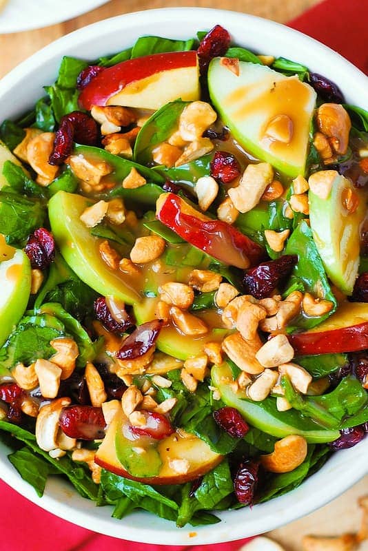 Apple Cranberry Spinach Salad with Cashews and Balsamic Vinaigrette in a bowl.