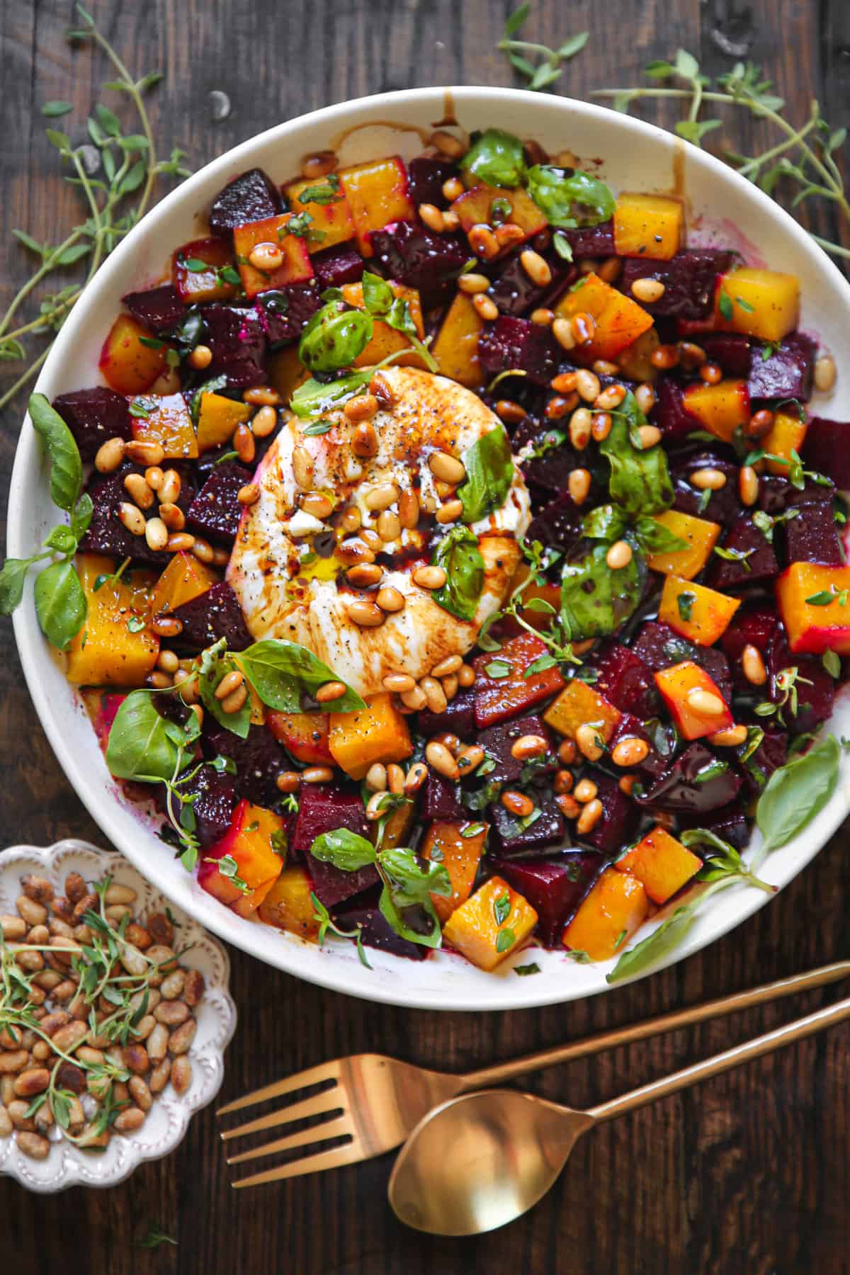 Beet and Burrata Salad with Pine Nuts and Balsamic Dressing on a white plate.